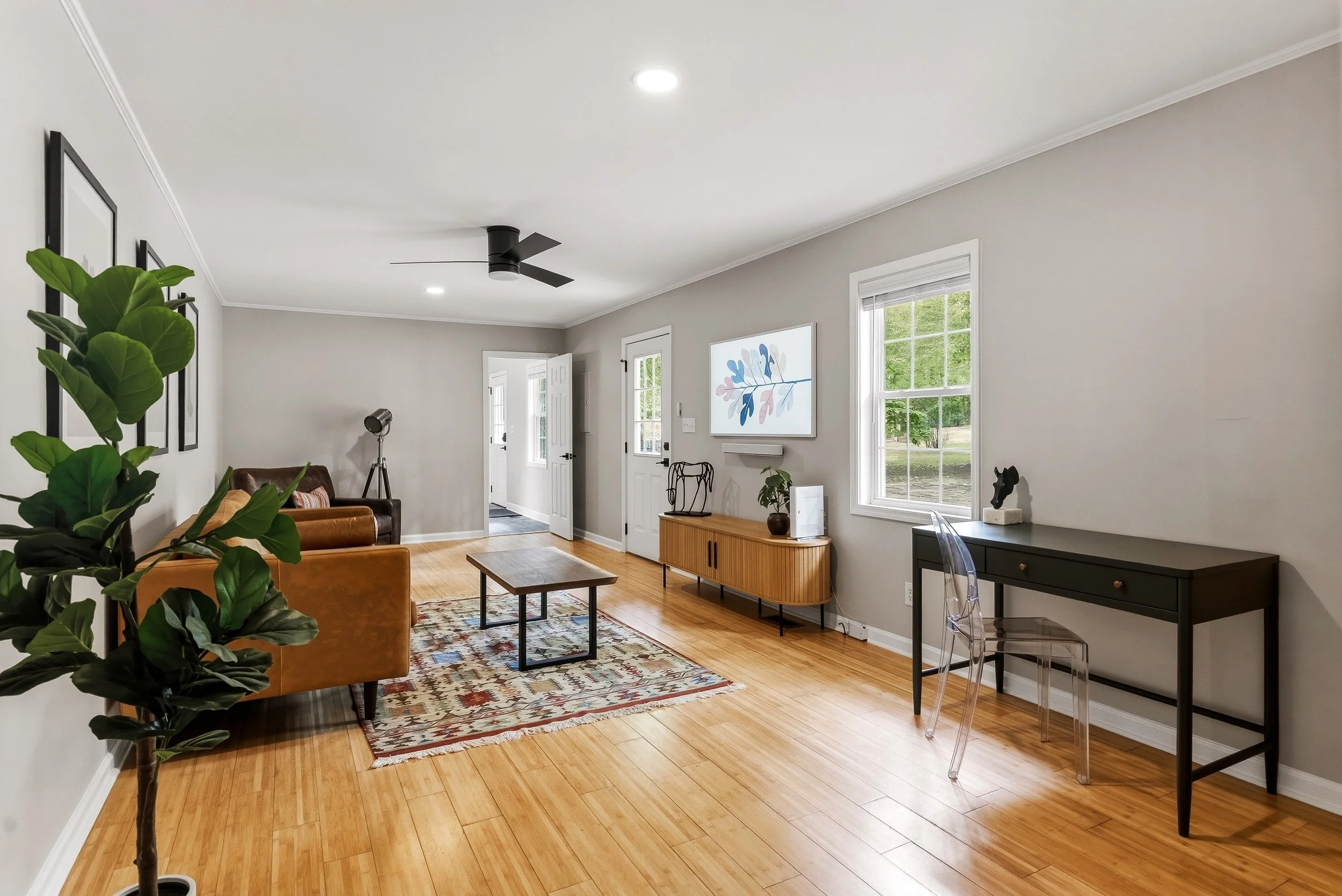 Modern, comfortable living area with desk and TV.