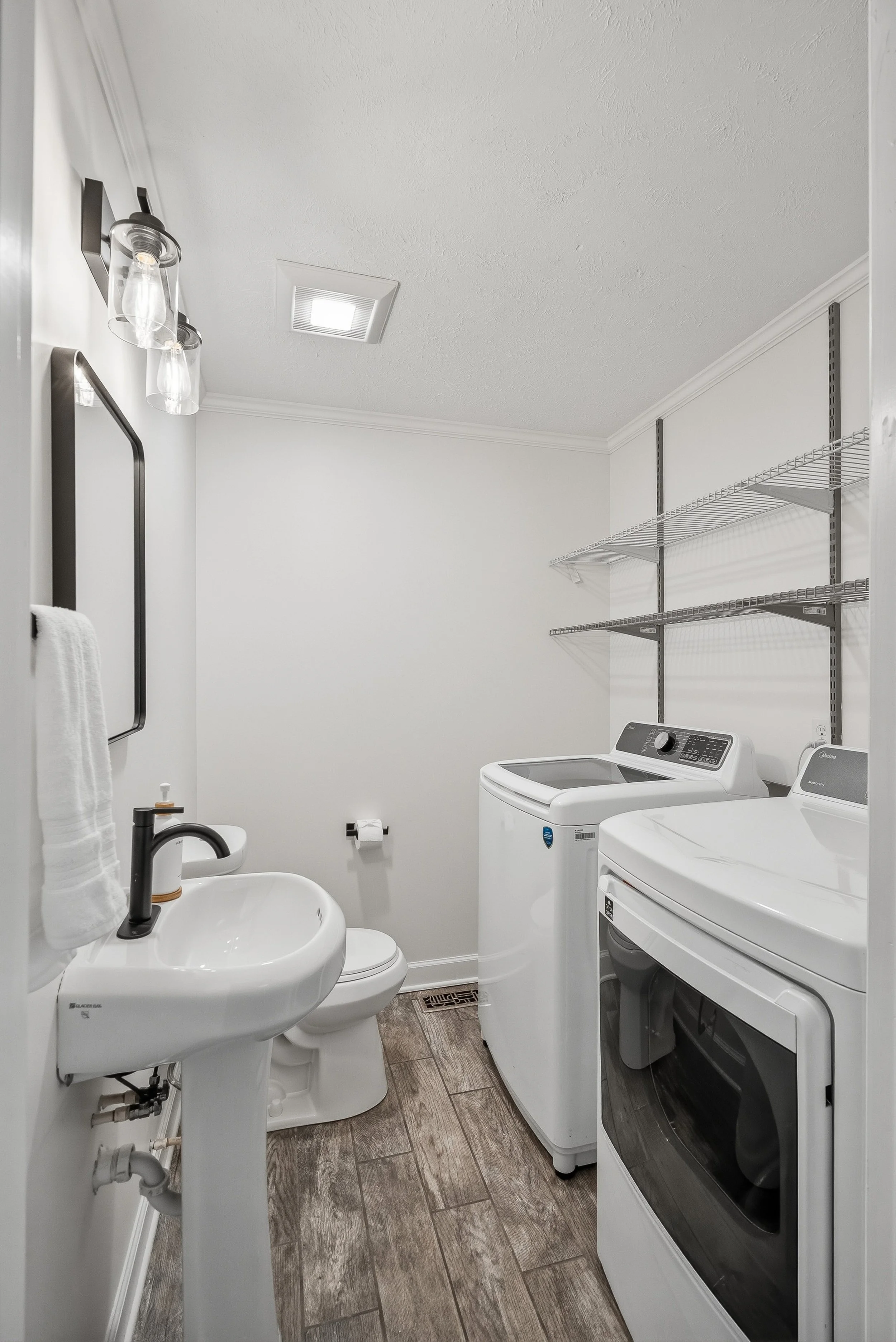 Laundry room and half bath with full-sized washer and dryer.
