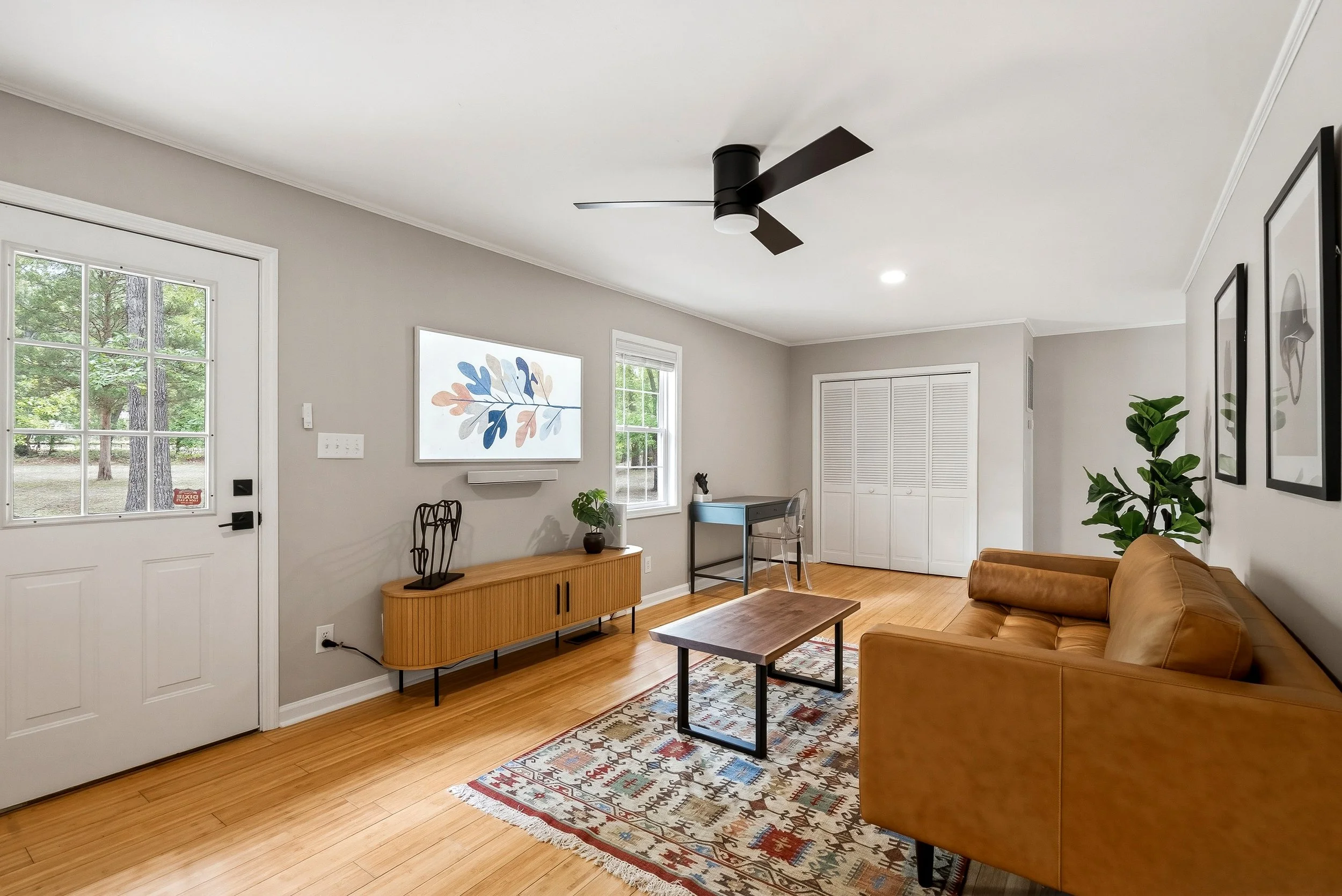 Modern, comfortable living area with desk and TV.