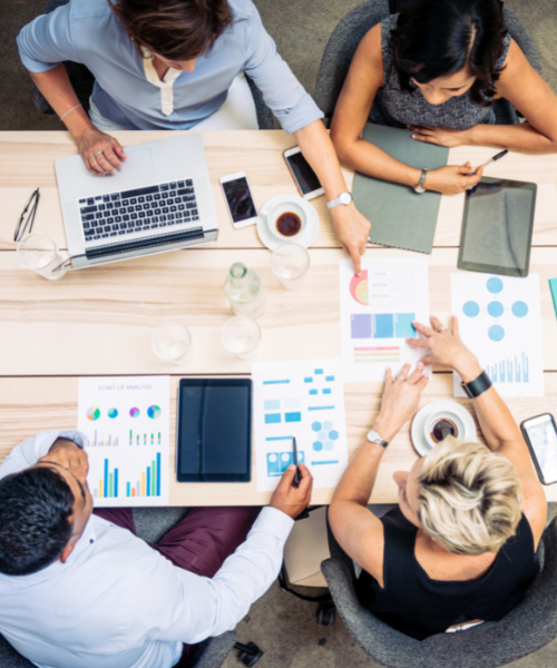 4 team members working together around a table