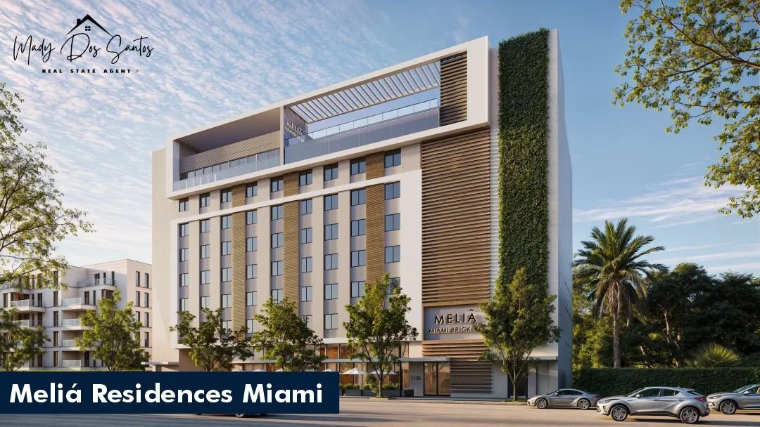 Imagen de un edificio moderno llamado Melía Residences Miami con muchas ventanas, árboles en la calle y autos estacionados frente a él.