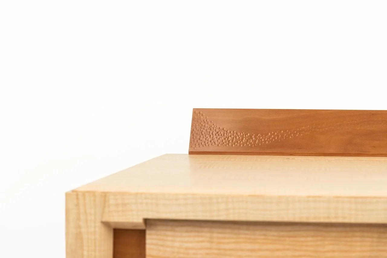 Journal Desk — top corner detail showing the junction of Swiss pear upstand and rippled ash desktop, hand-made by Henry Crabb