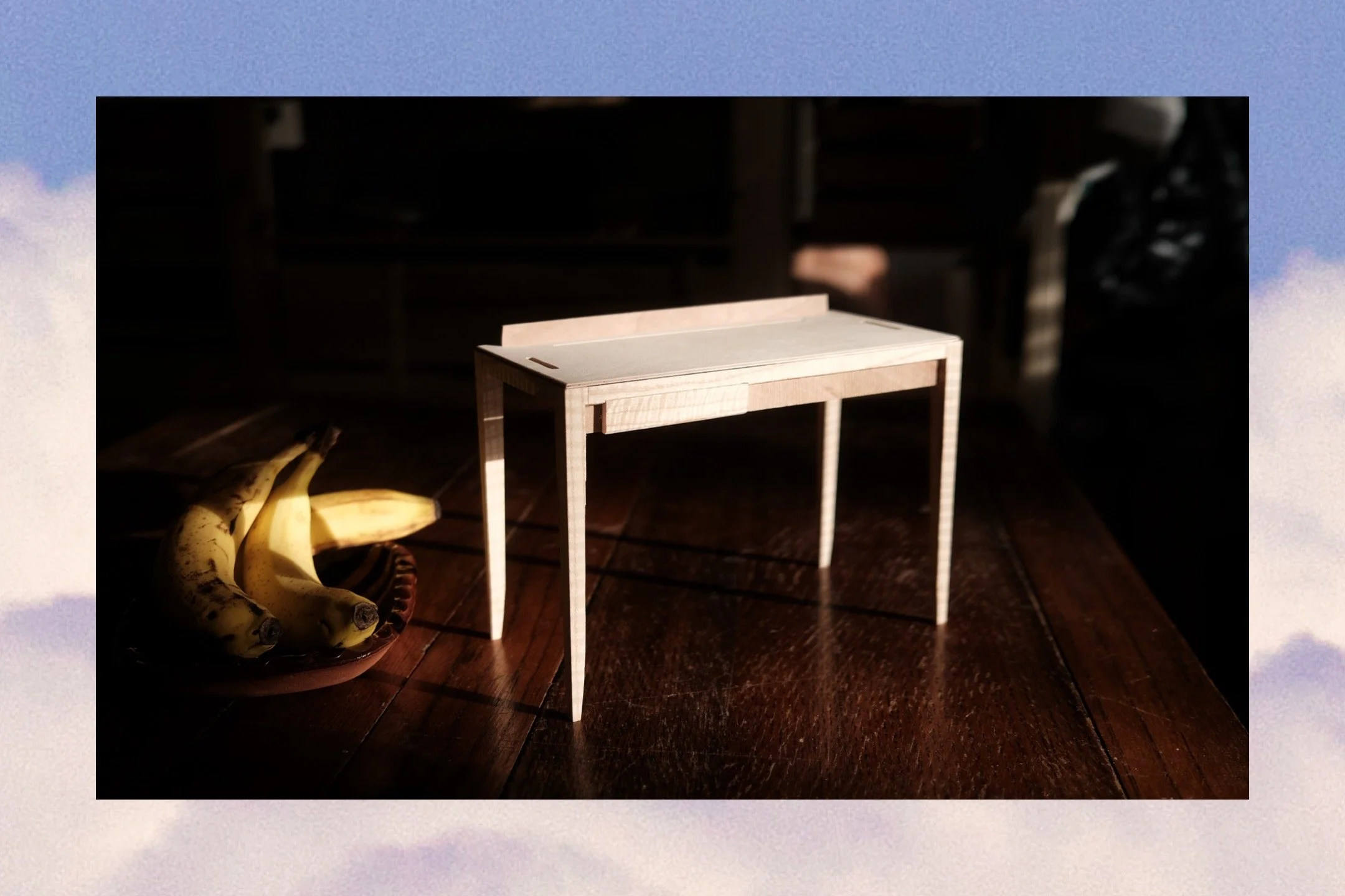 Scale model of a bespoke writing desk in pale ash, photographed in natural light with a banana by furniture designer-maker Henry Crabb, West Cornwall