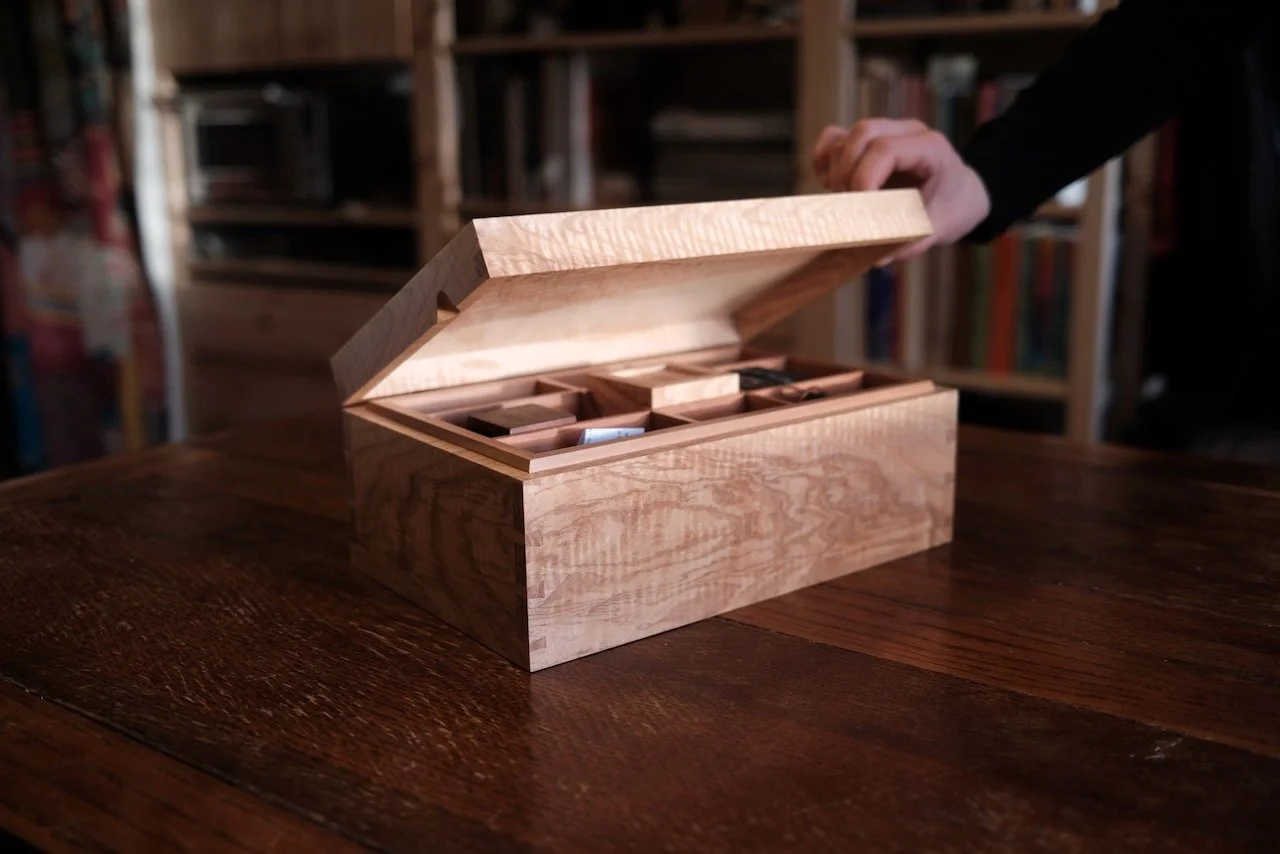 Bespoke engagement jewellery box in Devon rippled ash being opened to reveal the English pear wood tray — hand-made by Henry Crabb