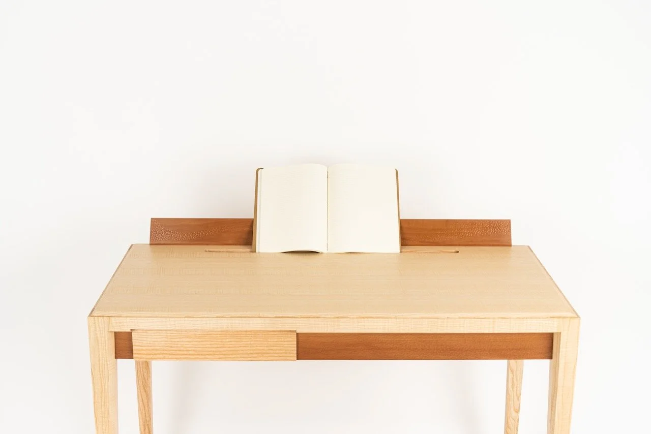 Journal Desk in Devon rippled ash and Swiss pear — open notebook resting on the upstand, made by furniture designer-maker Henry Crabb, West Cornwall