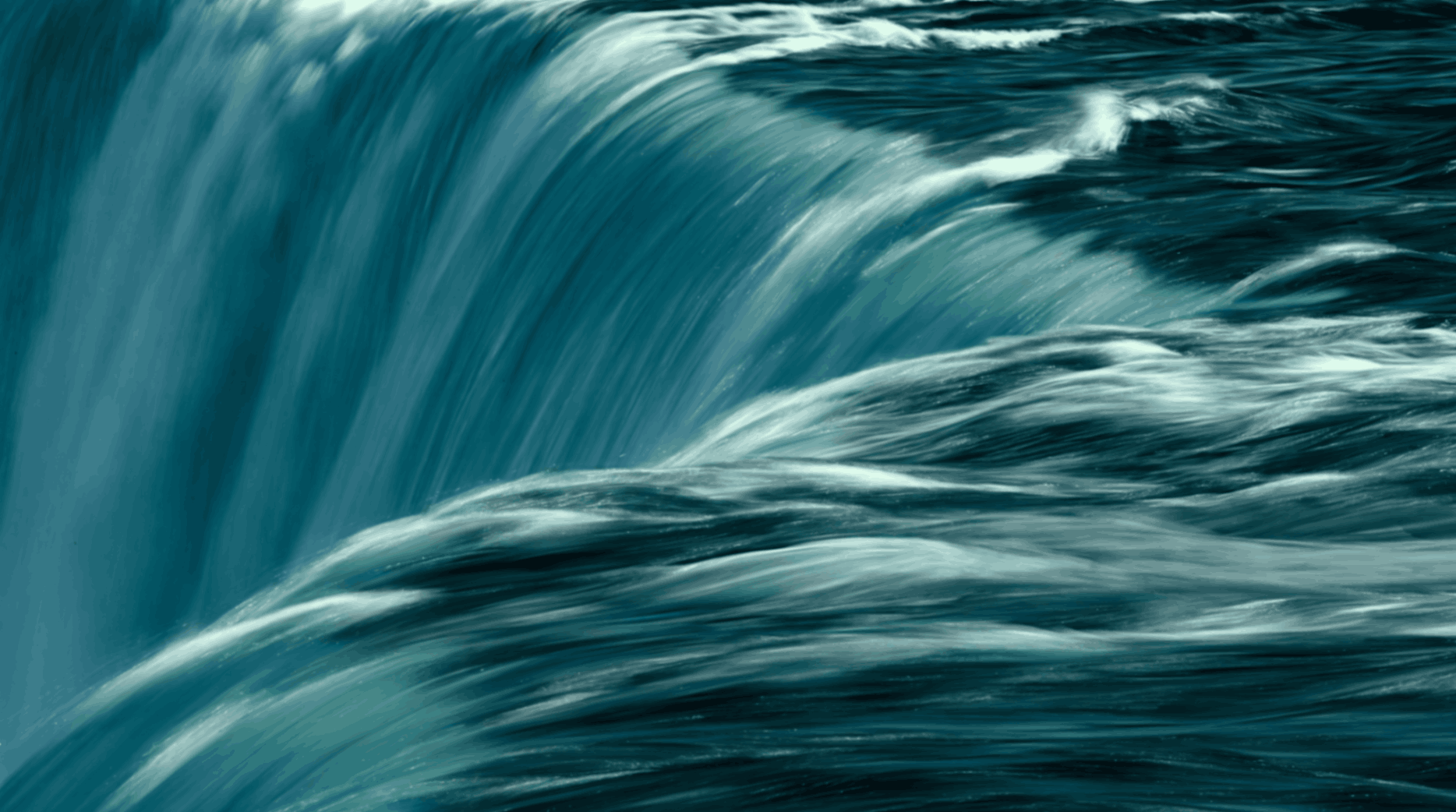 A large ocean wave curling over with blue and white hues.