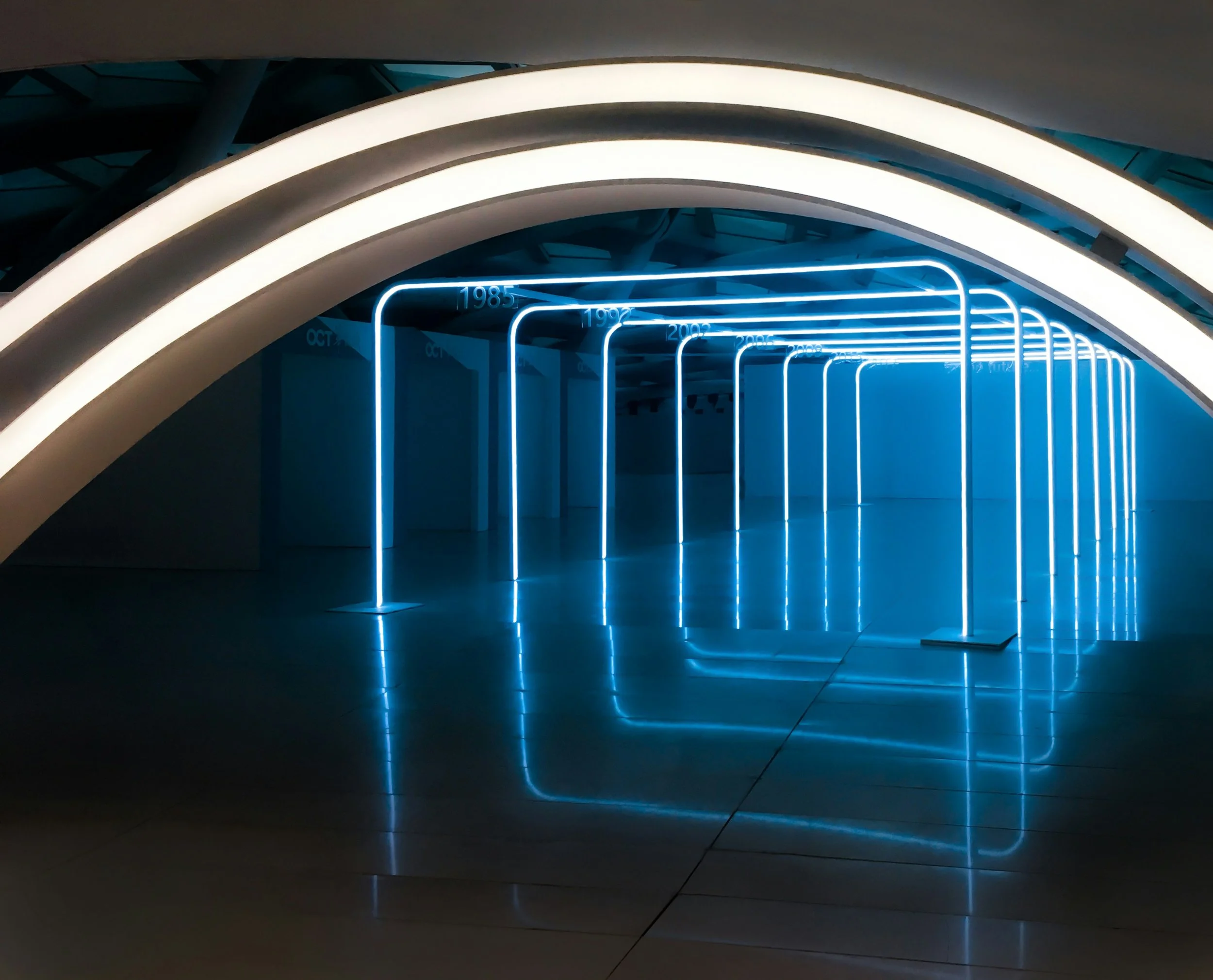 Neonlichtinstallationen in einer dunklen, modernen Ausstellungshalle, die den Verlauf der Jahre 1985 bis 2011 markieren.