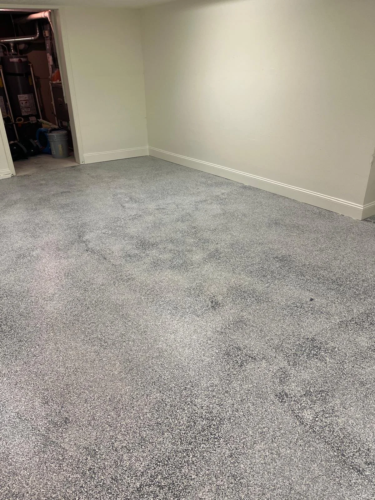 Empty room with gray carpet, white walls, and a small open closet or utility storage area in the corner.
