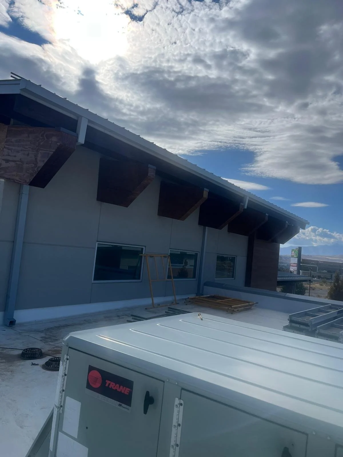 Construction site on the roof of a building with cloudy sky overhead.