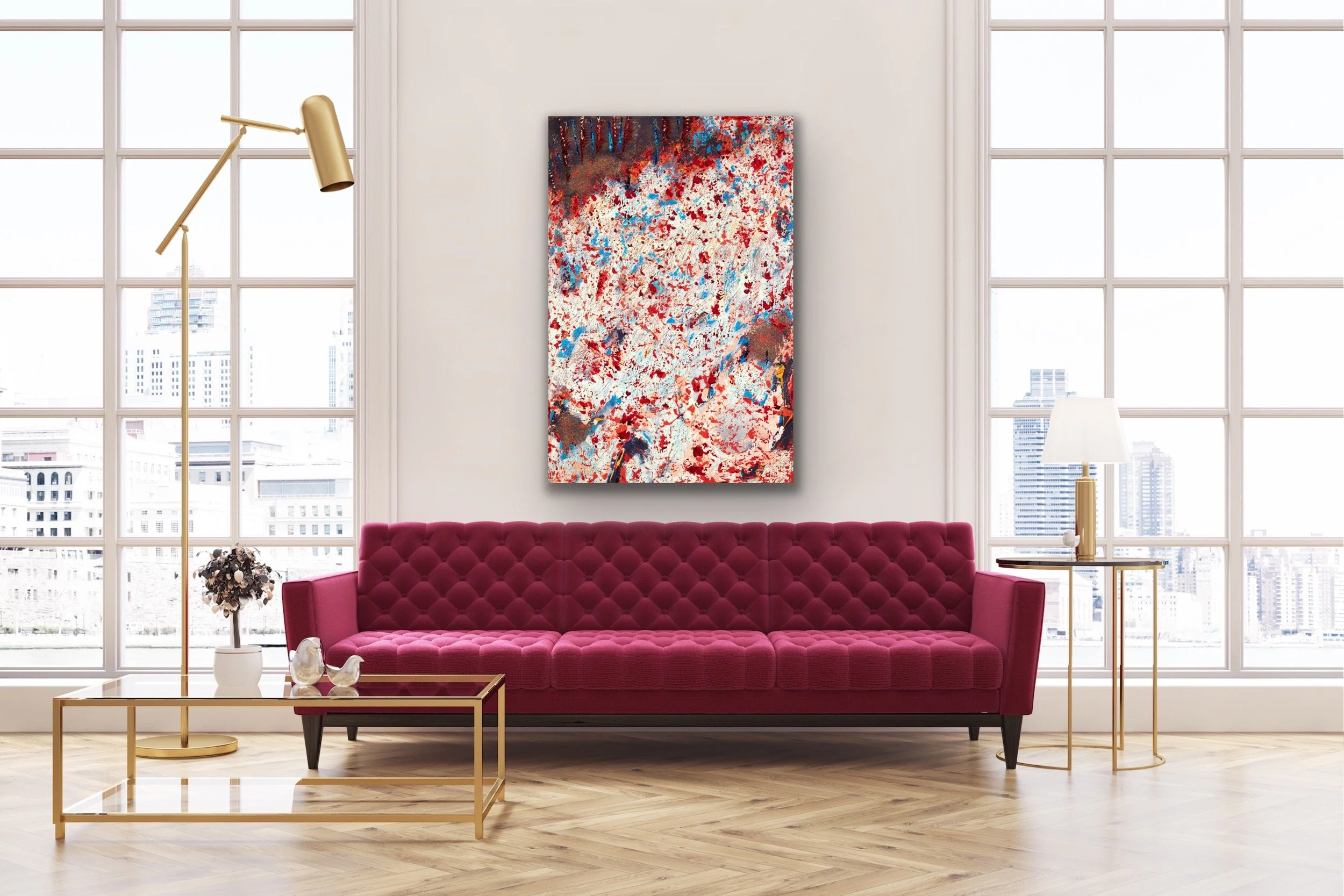 Living room with large windows, pink tufted sofa, abstract artwork on the wall, glass coffee table, side tables with lamps, and decorative items.