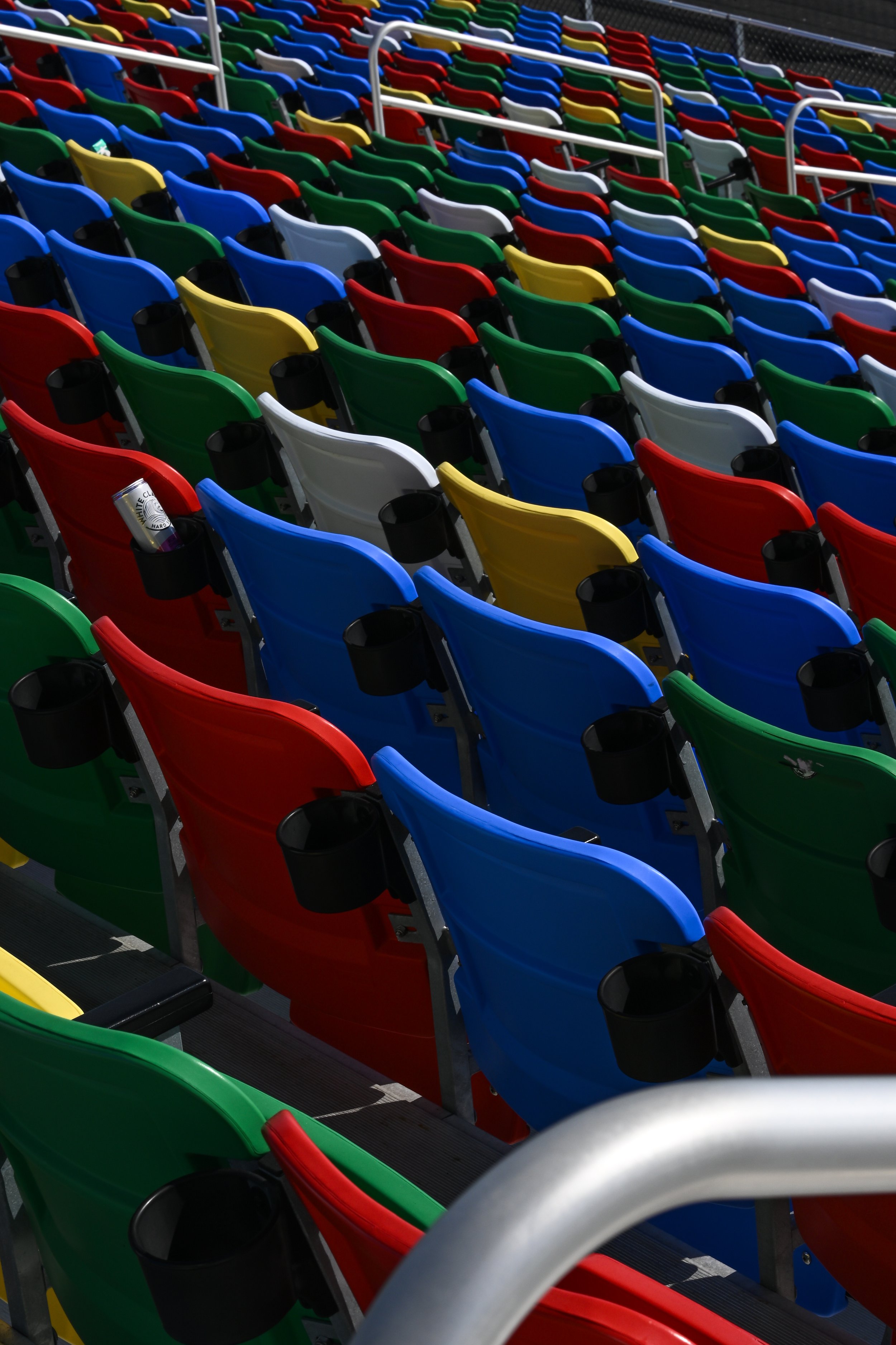 Colorful stadium seats in red, blue, green, yellow, and gray arranged in rows.