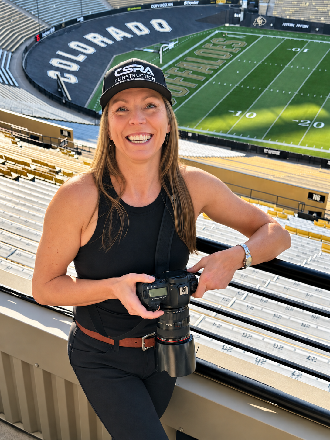 Photographer Lisa Doane holding her camera at the CSRA Summit at Folsom Field in Boulder, Colorado.