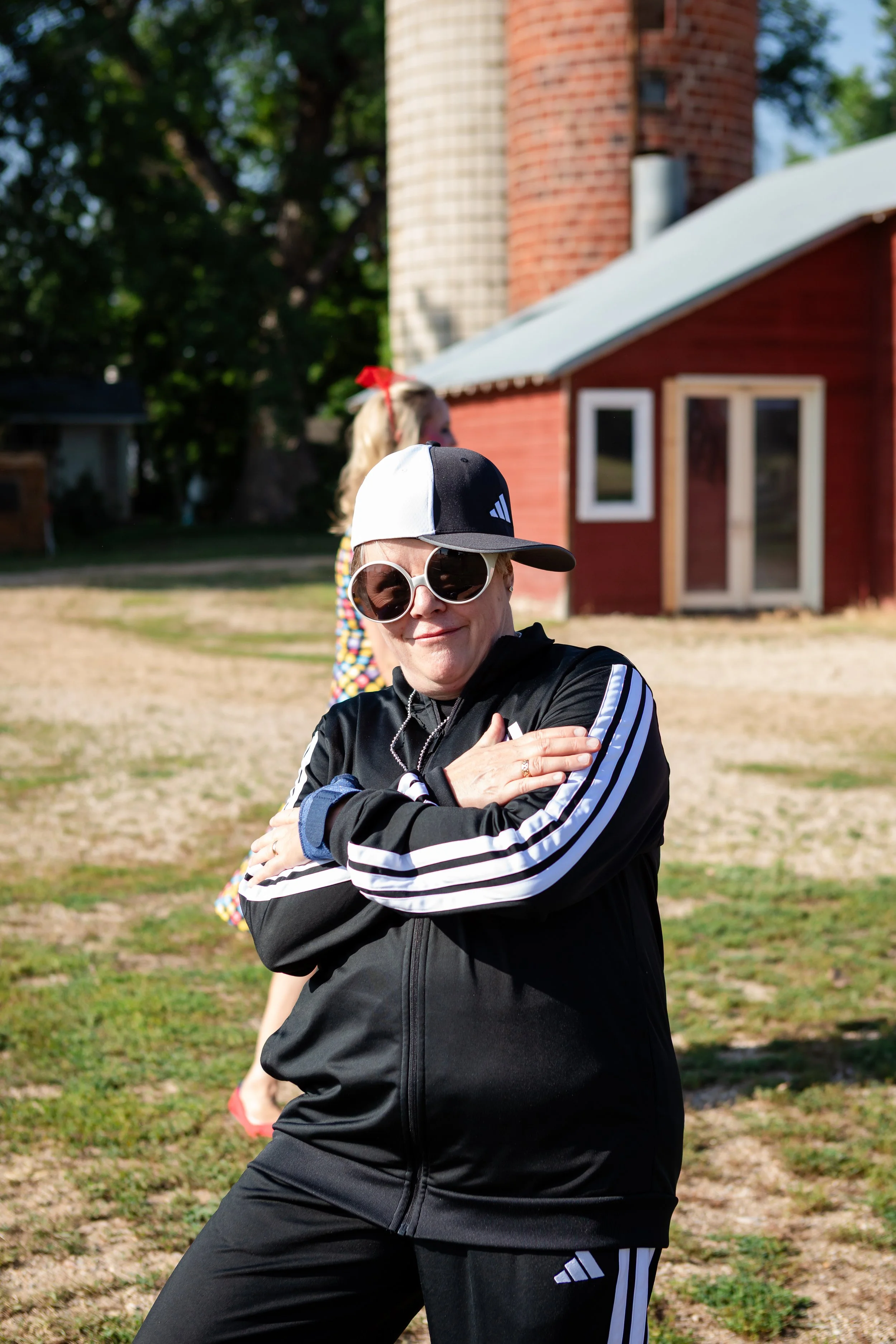 An outdoor lifestyle guest portrait session during a retro themed milestone birthday party at Old Elm Farm in Boulder, Colorado, with a classic red barn backdrop.