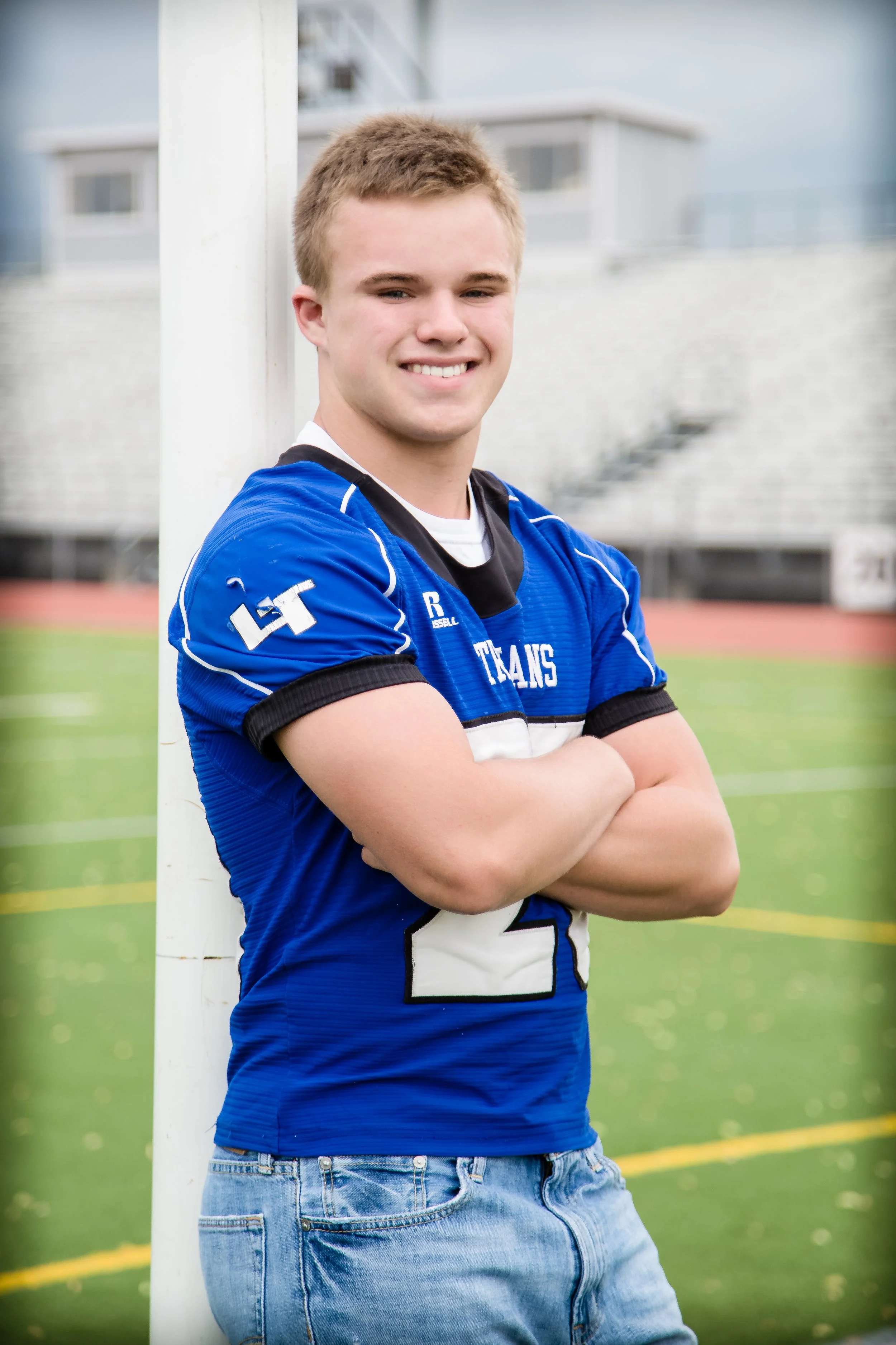 A male high school senior portrait session captured on the football field at Longmont High School in Longmont, Colorado, featuring an athlete in his sports jersey.
