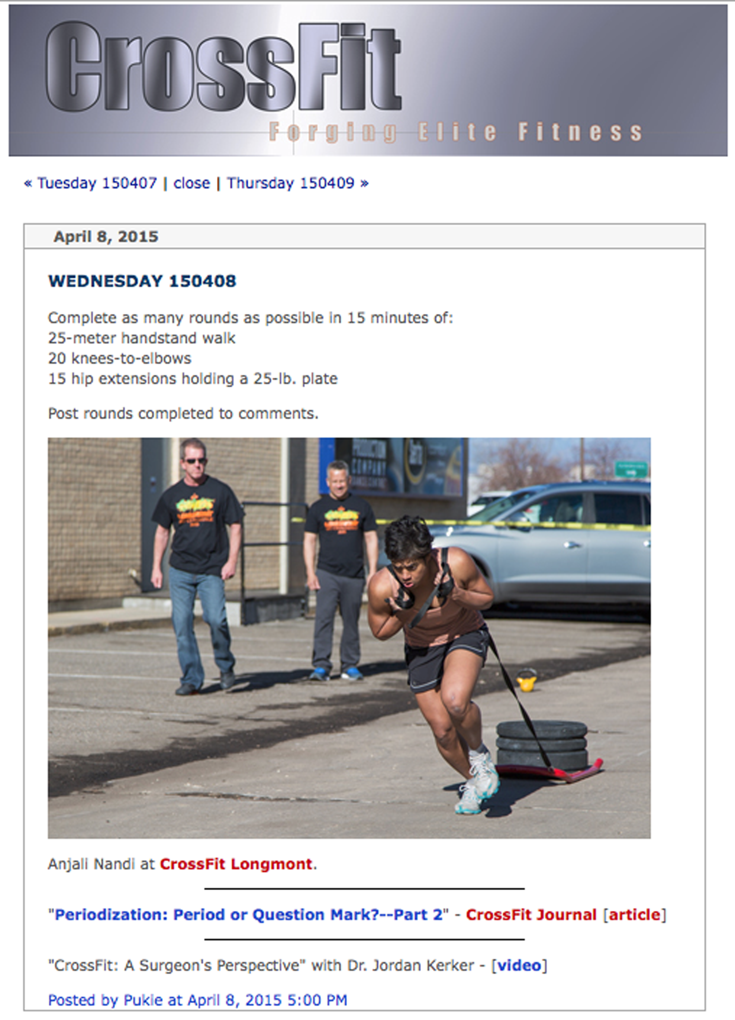 A woman participating in a CrossFit workout outdoors, pulling a sled loaded with weights, with three men watching nearby on a sunny day.