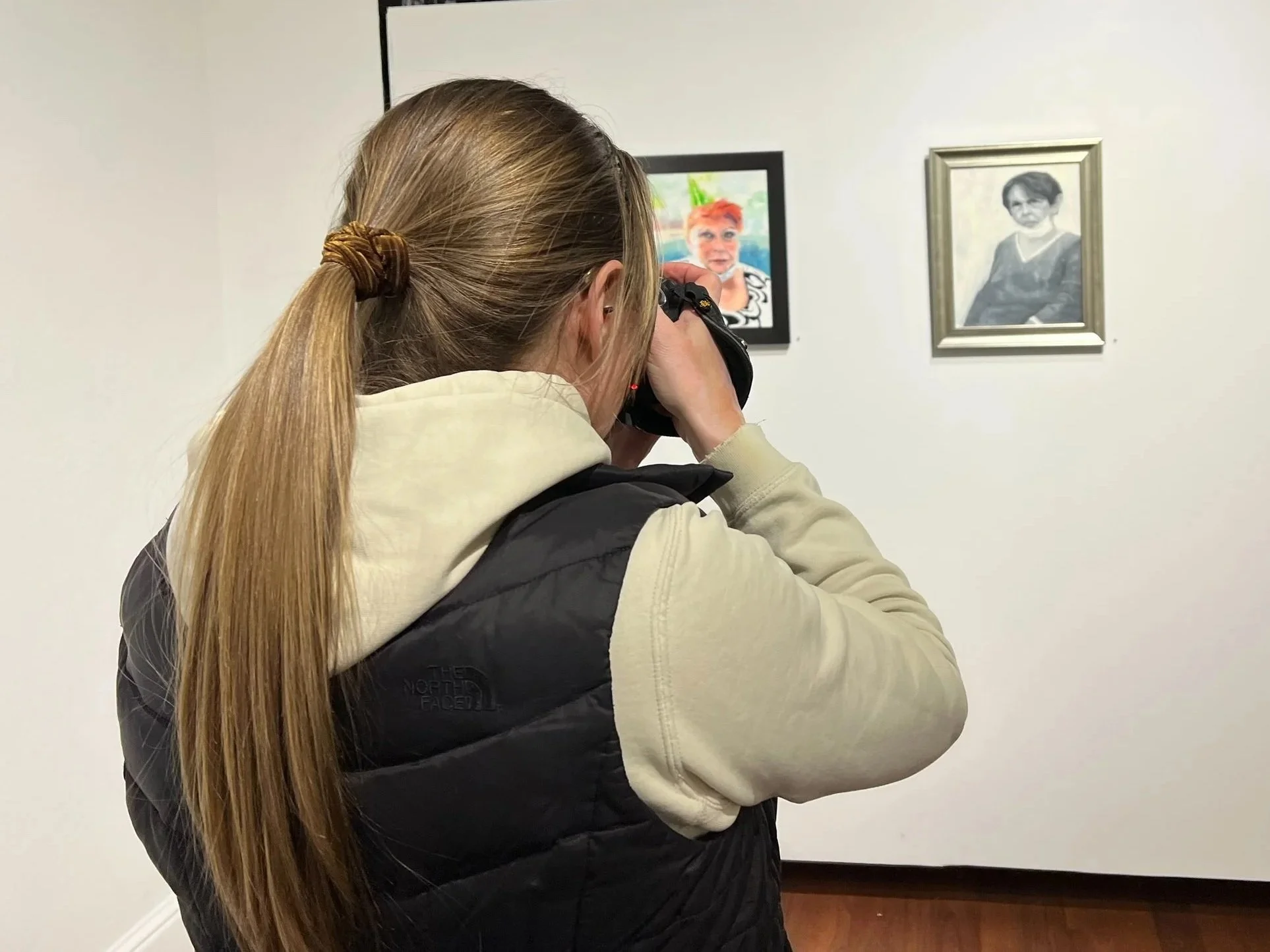 Art exhibition photographer Lisa Doane documenting an art exhibit display and framed artwork installation at the Firehouse Art Center in Longmont, Colorado.