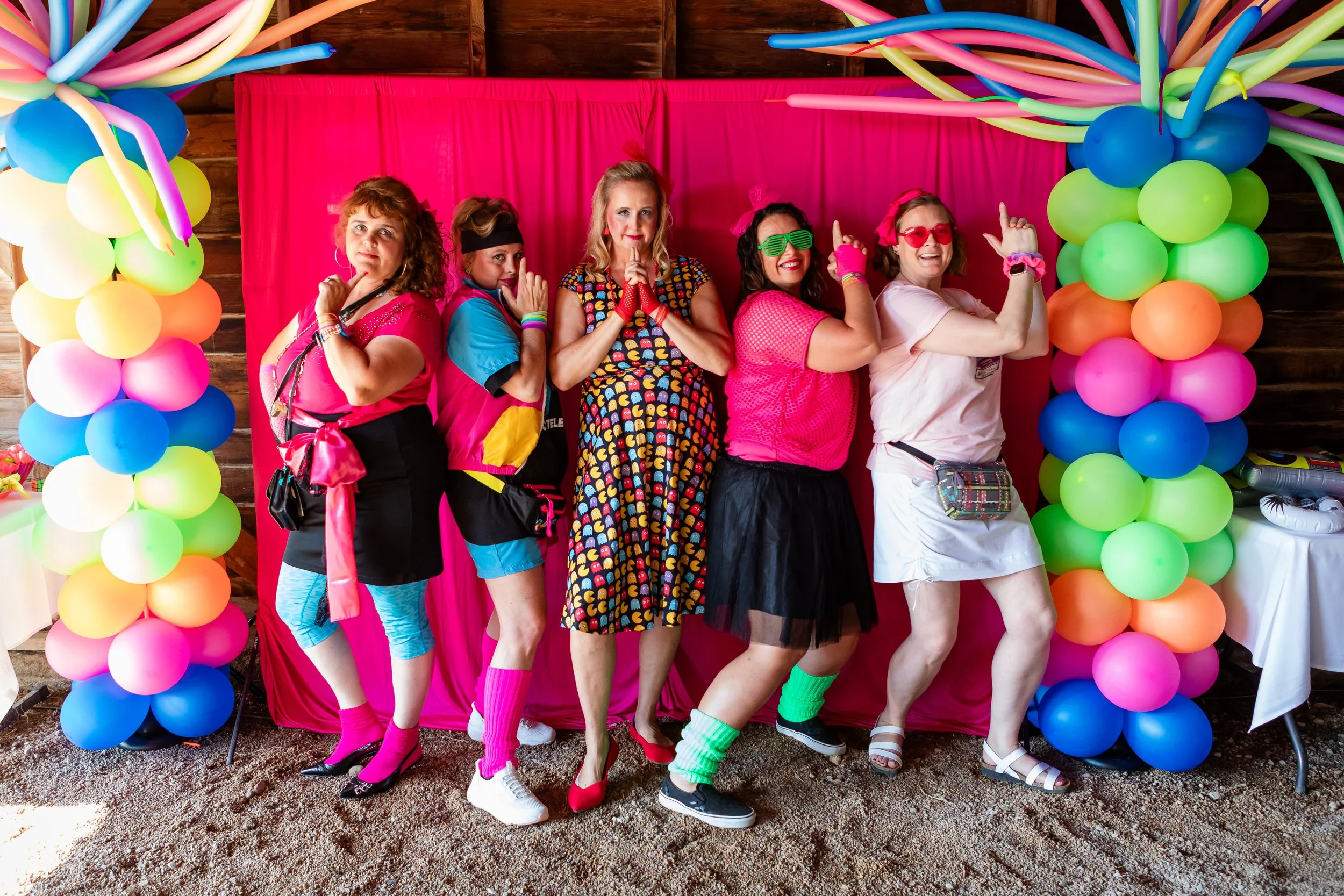 A vibrant 50th birthday celebration with a fun retro 80s theme and colorful balloon arch, captured on location at Old Elm Farm in Boulder, Colorado, by Lisa Doane Photography.