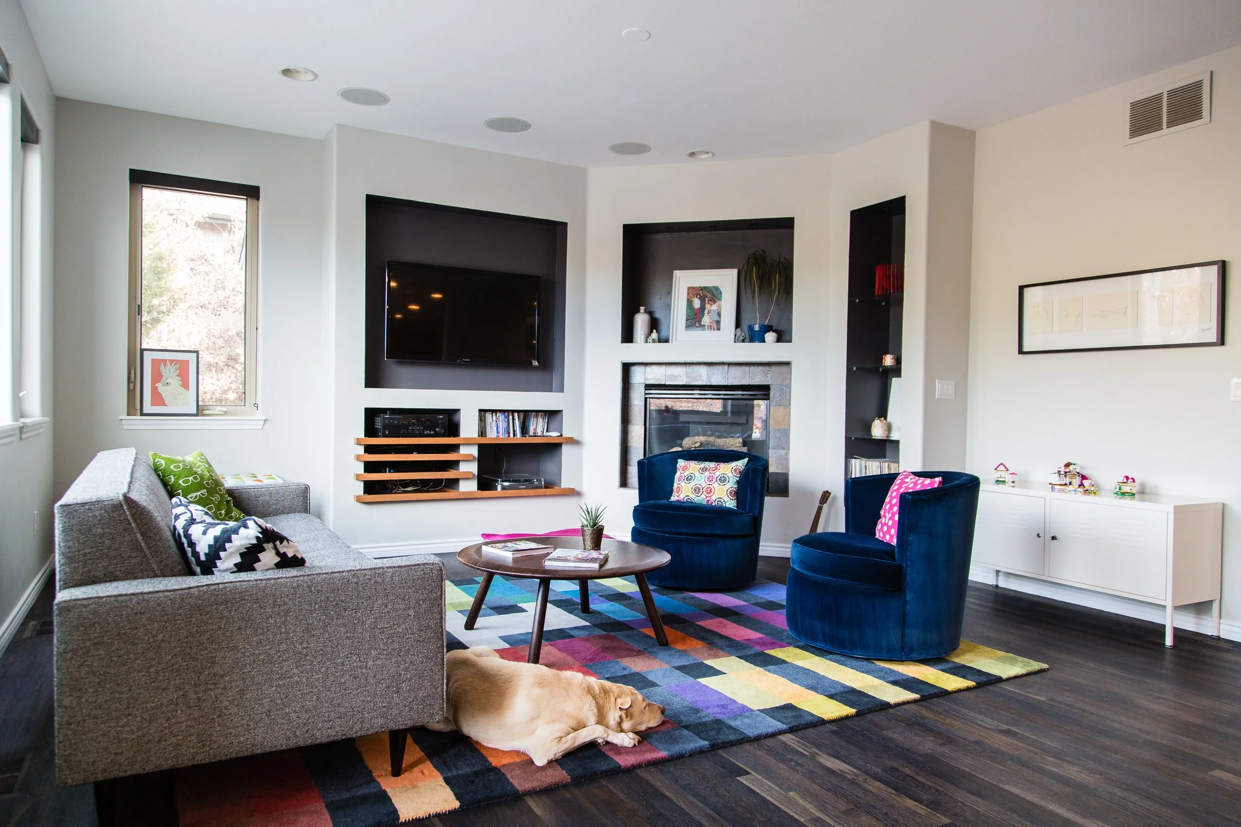 Editorial home design photography for Boulder Lifestyle Magazine featuring a modern living room with a gray sofa, colorful geometric rug, and custom built-in shelving.