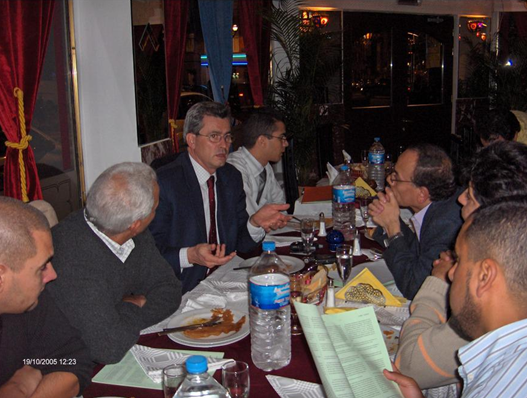 Group of men having a discussion at a restaurant table.