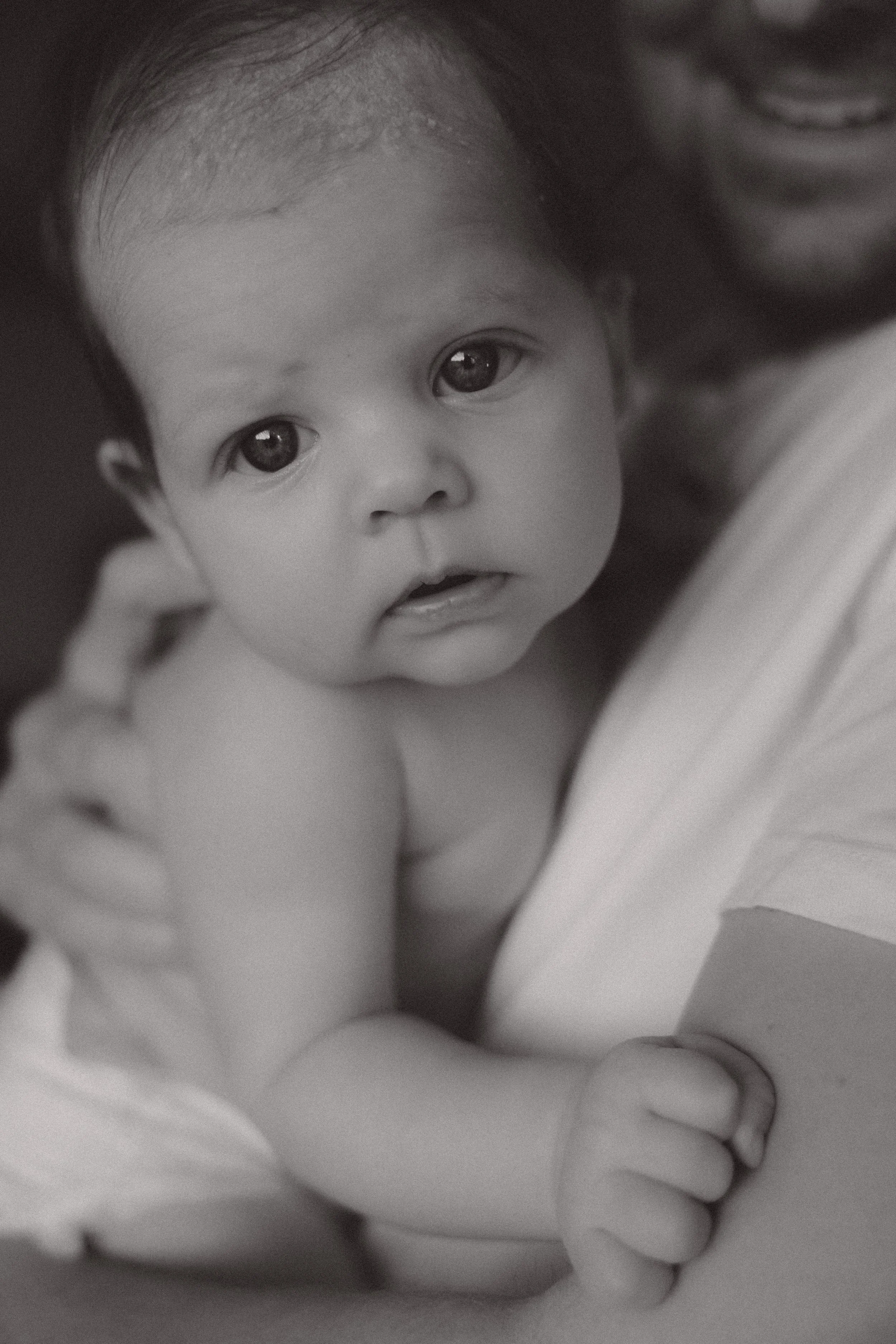 Newborn fotografie in Emmen – pasgeboren baby veilig in armen van ouder