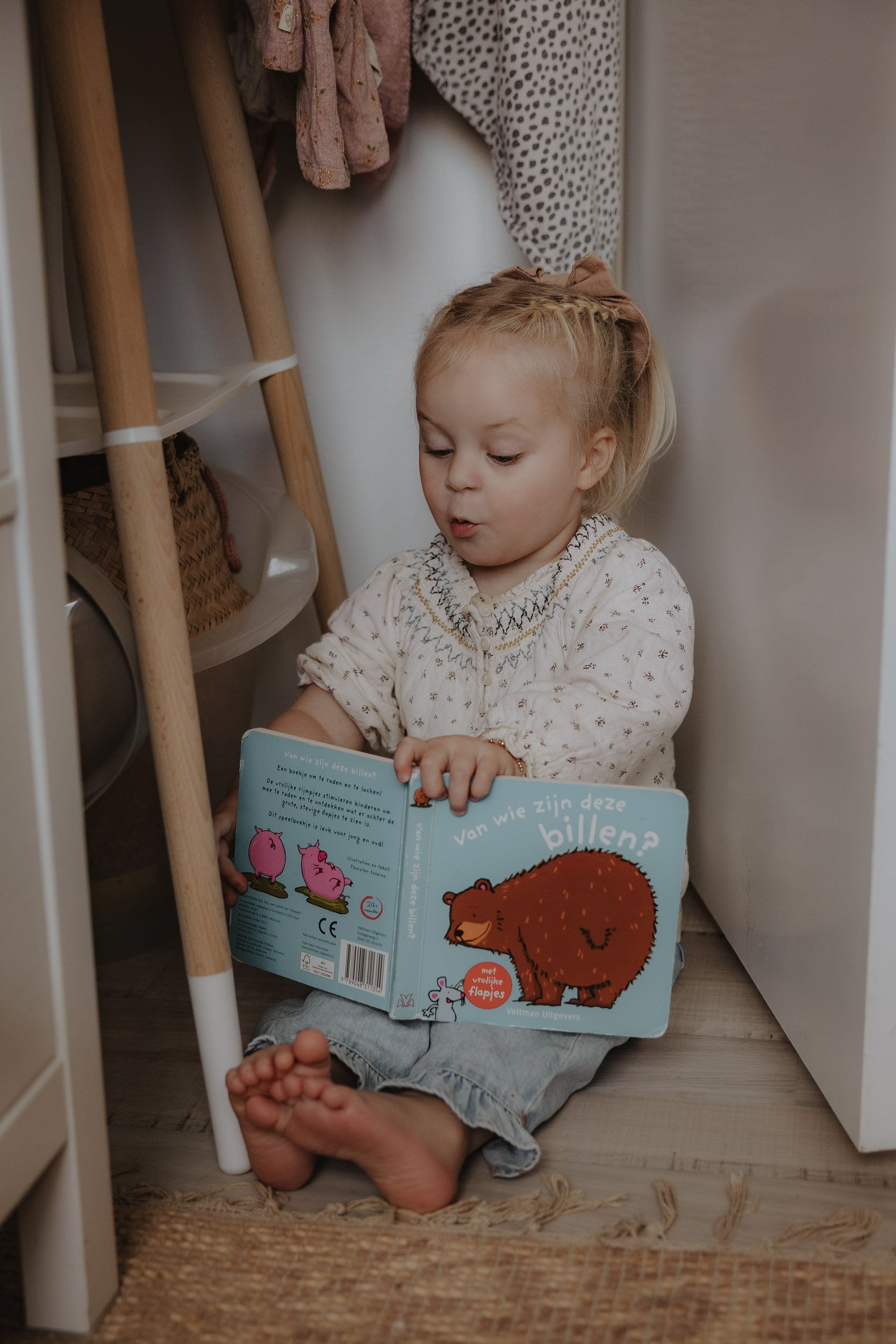 kinder fotografie met een meisje die verrast een boekje leest mooi gevangen moment in Nederland Groningen of Emmen newborn fotografie lifestyle