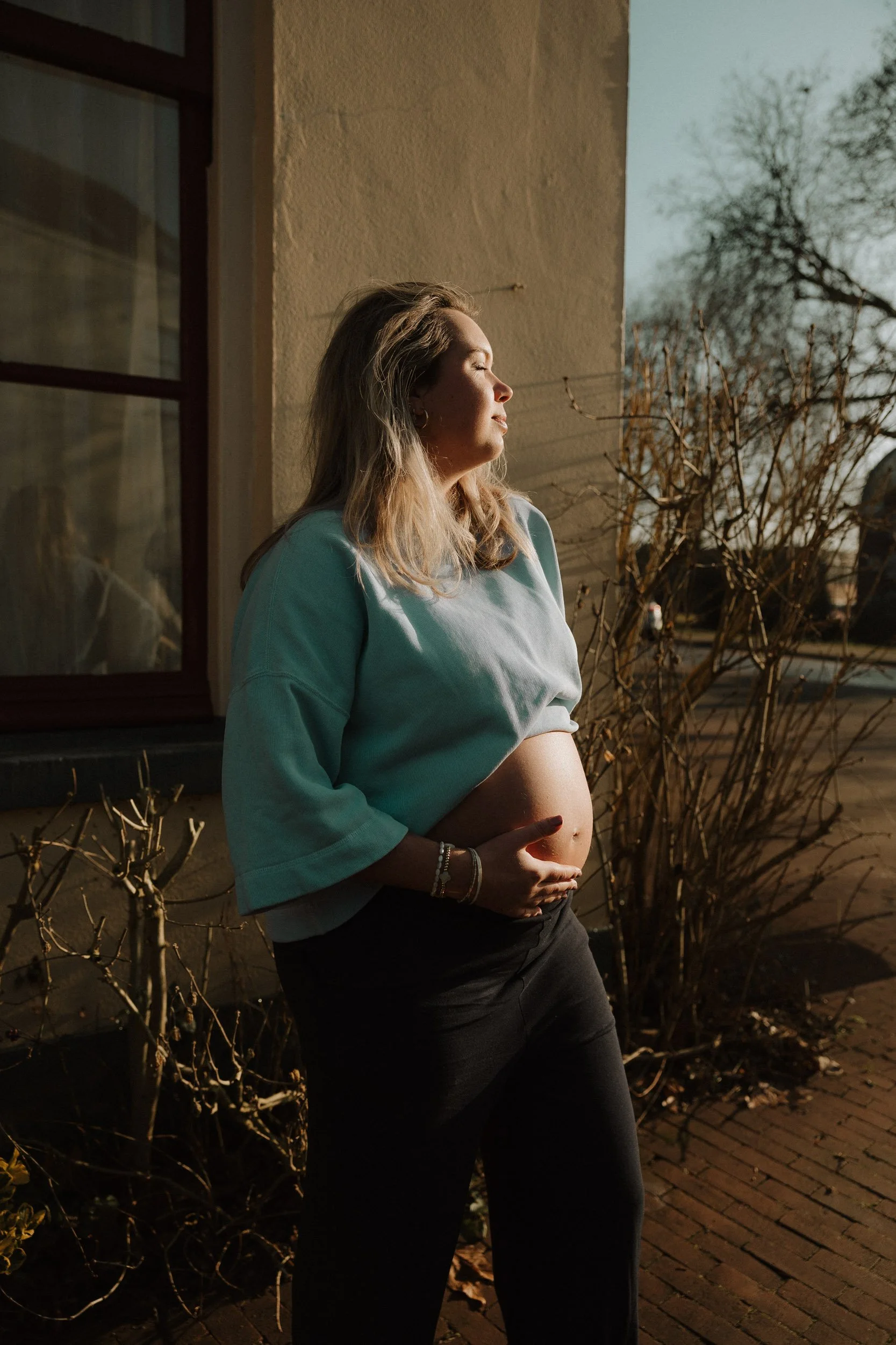 Zwangerschapsfotografie in Emmen – zwangere vrouw in warm avondlicht tijdens zwangerschapsshoot