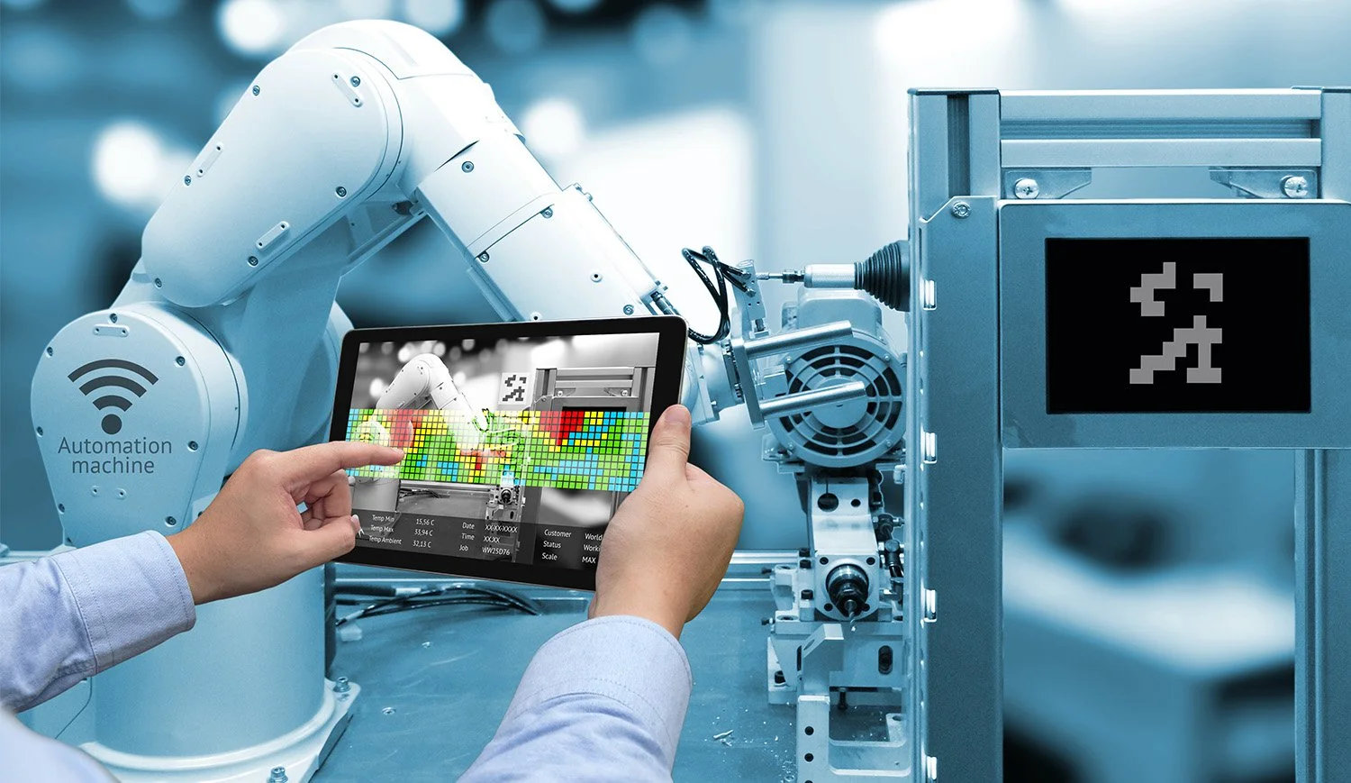 Close-up of a person operating a tablet to monitor industrial robot arm during automation process in a manufacturing setting.