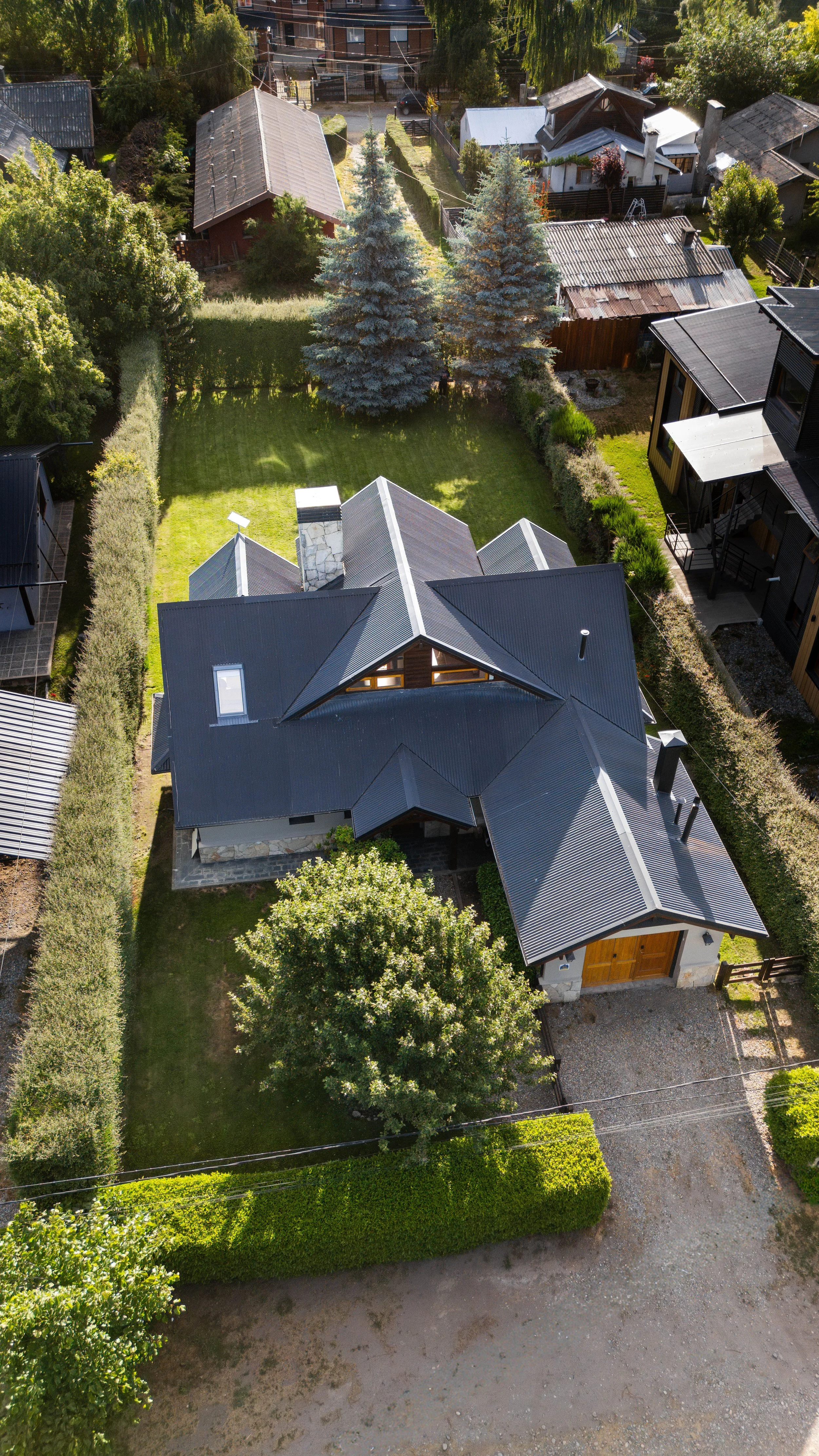 Aerial view of Casa Bonita, surrounded by a well-maintained yard with green grass, and trees.
