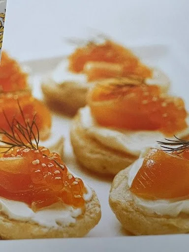 Dill and chive blini topped with apple wood smoked trout