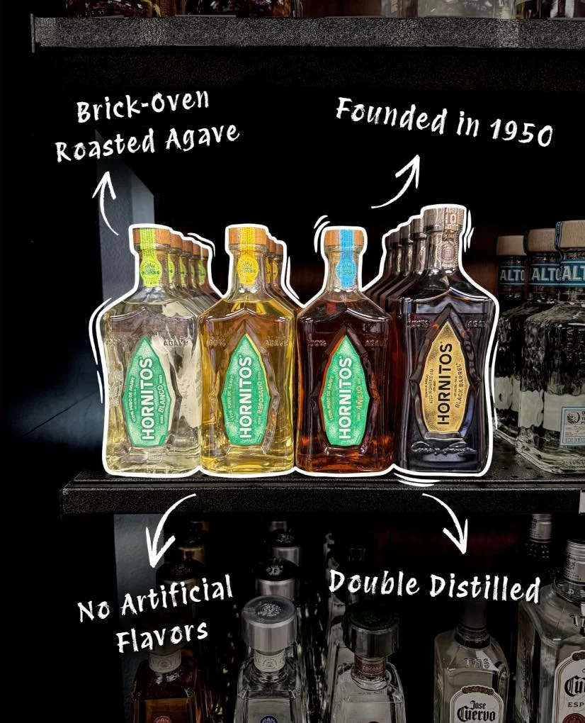 Display of Hornitos tequila bottles on a shelf with handwritten annotations indicating they are made with 100% agave, founded in 1950, with no artificial flavors, and double distilled.
