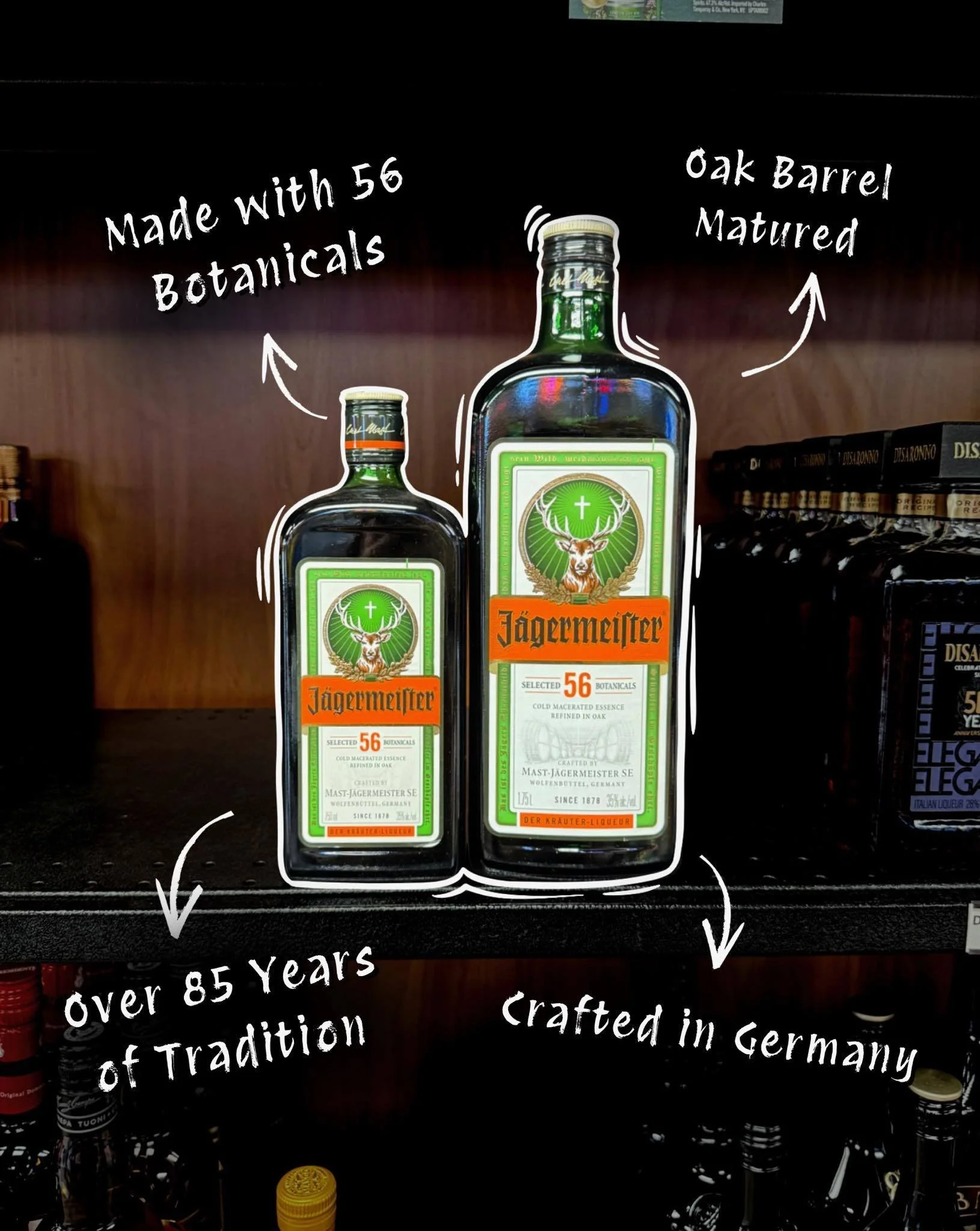 Two bottles of Jägermeister herbal liqueur, one large and one small, with handwritten annotations describing it as made with 56 botanicals, crafted in Germany, over 85 years of tradition, and matured in oak barrels.