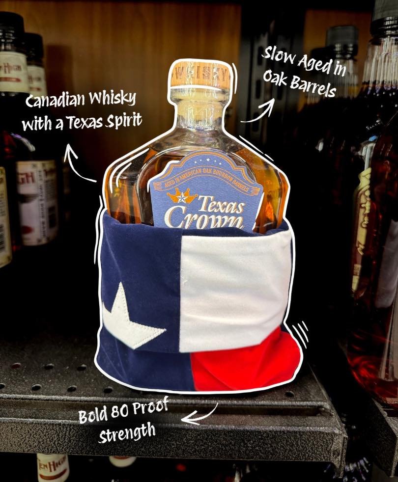 A bottle of Texas Crown Canadian Whisky wrapped in a festive Texas-themed sleeve with a star and the Texas flag colors, placed on a shelf with handwritten notes indicating it is slow aged in oak barrels, 80 proof strength, and has a Texas and Canadia