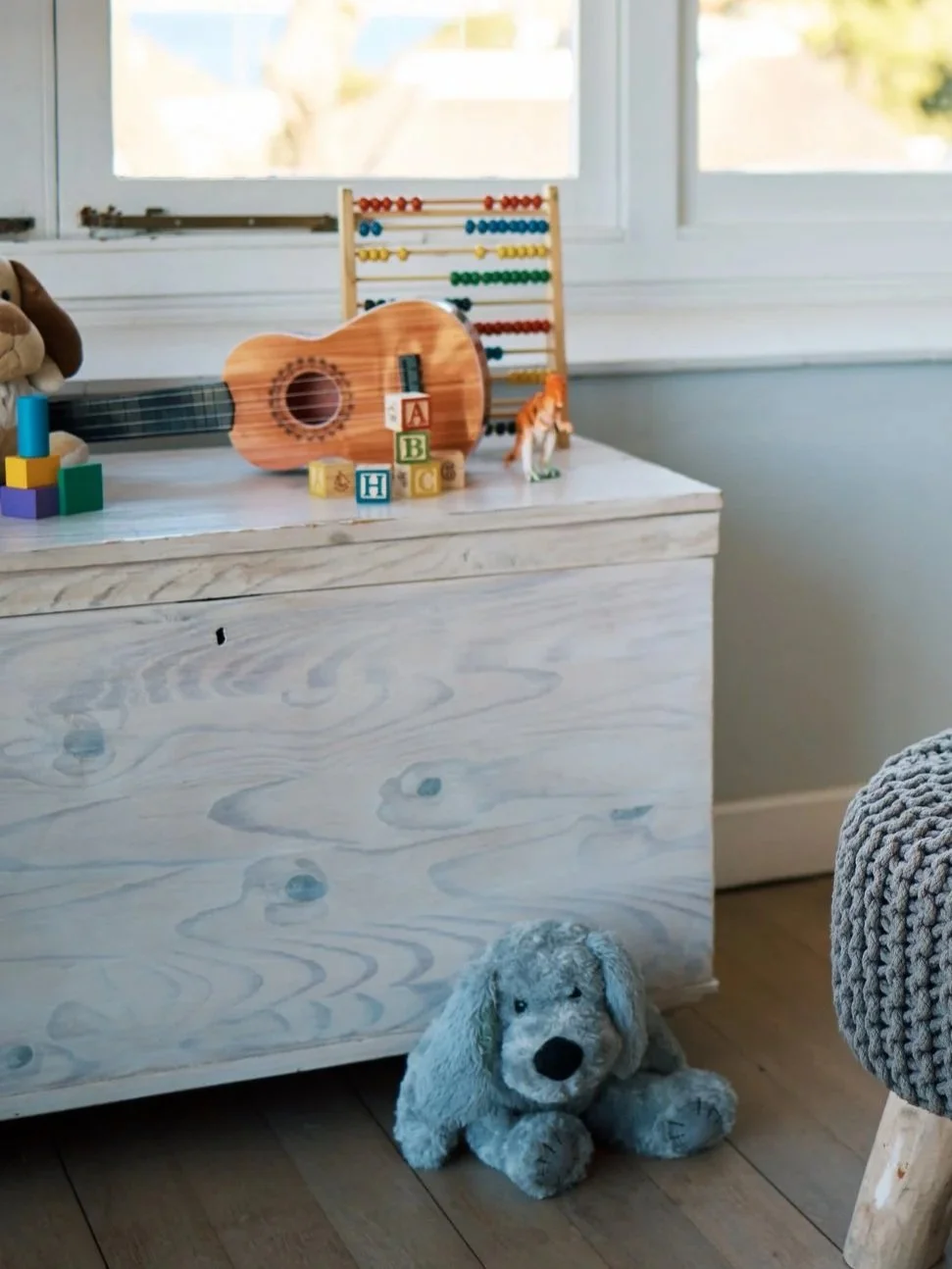 Wooden educational toys, alphabet blocks, and stuffed animals in a bright home
