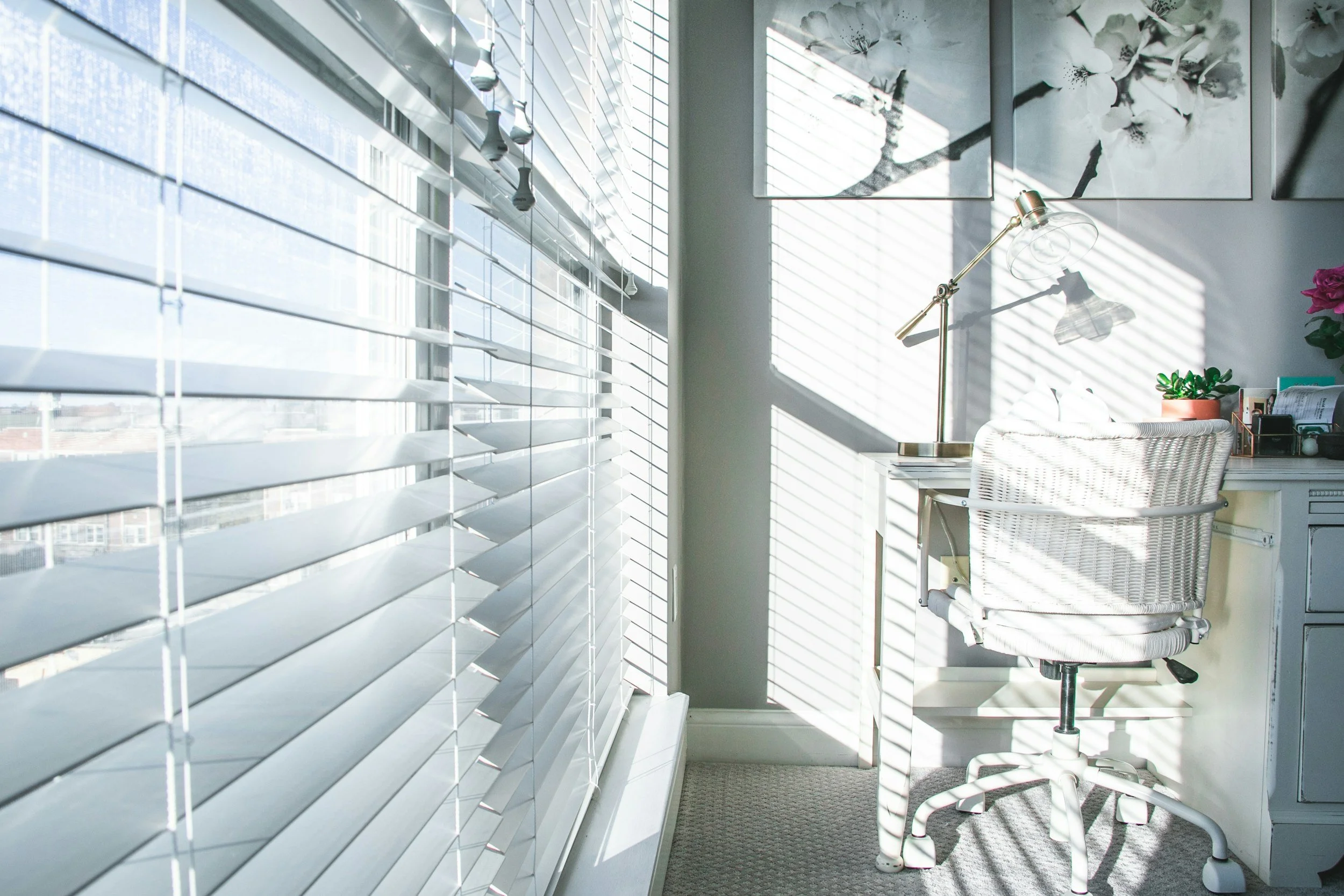 Daylight filtered through white window blinds in a bright home interior.