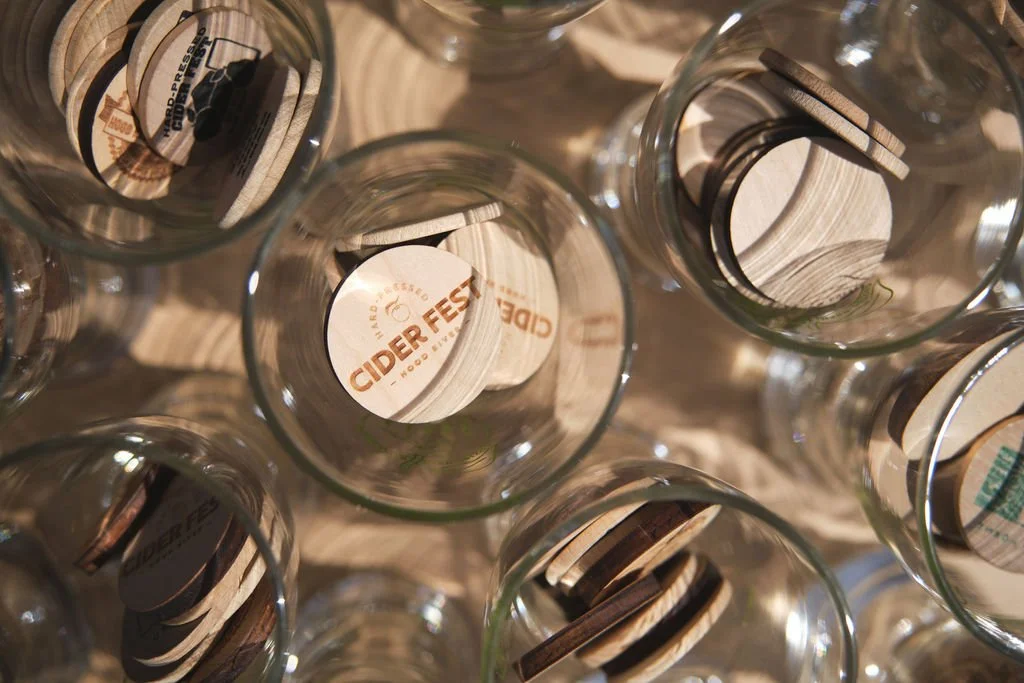 Multiple empty clear glass jars with lids inside, viewed from above, some with labels reading "Cider Fest".