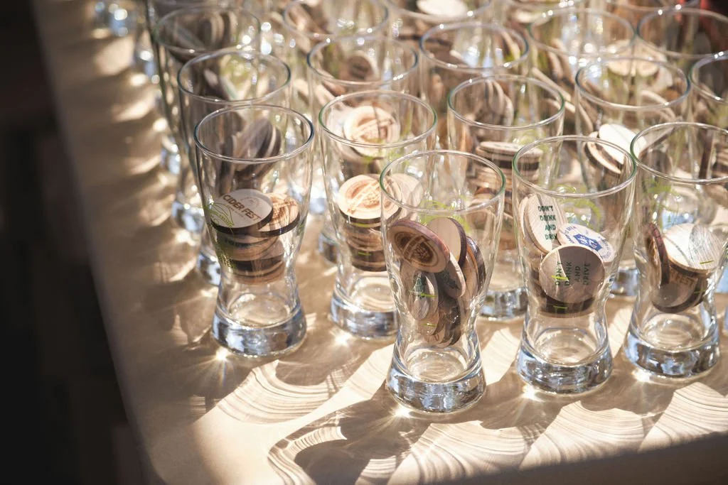 Multiple empty wine glasses on a table with sunlight casting shadows.