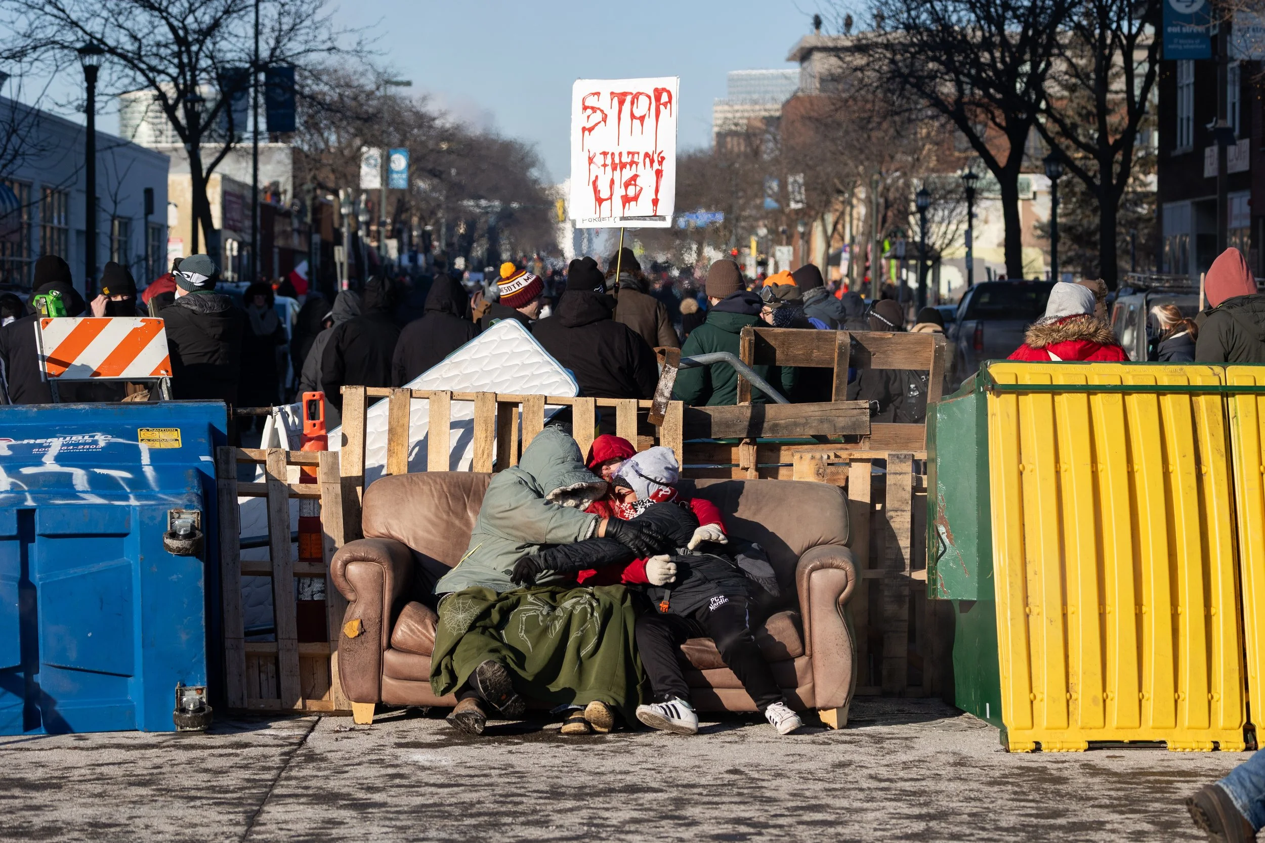 Protesters hug on a couch set up as part of a barricade on Nicollet Ave. in Minneapolis hours after Alex Pretti was killed by federal immigration officers on Jan. 25, 2026.