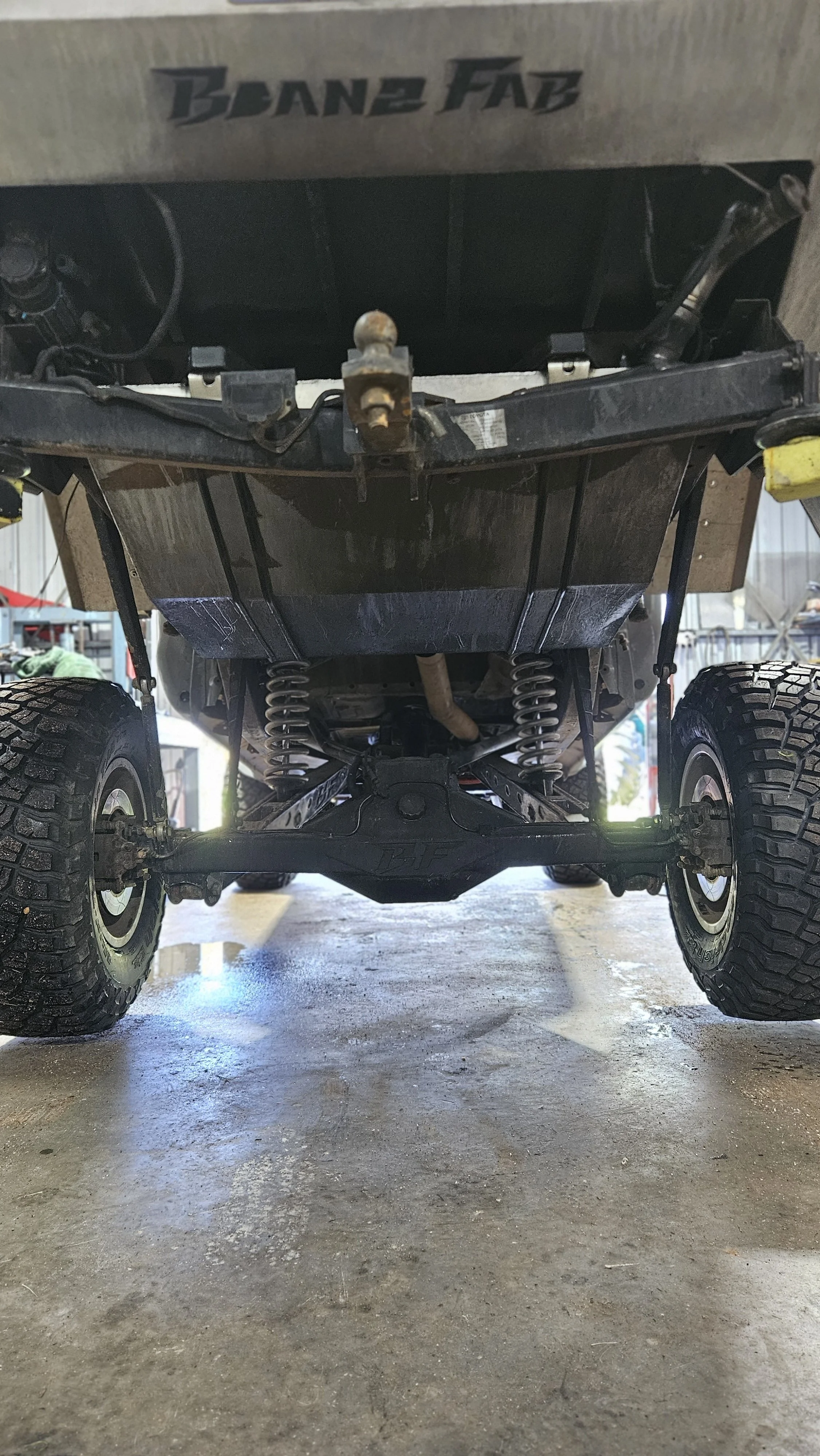 Underneath view of a vehicle showing the suspension, wheels, and underside components.