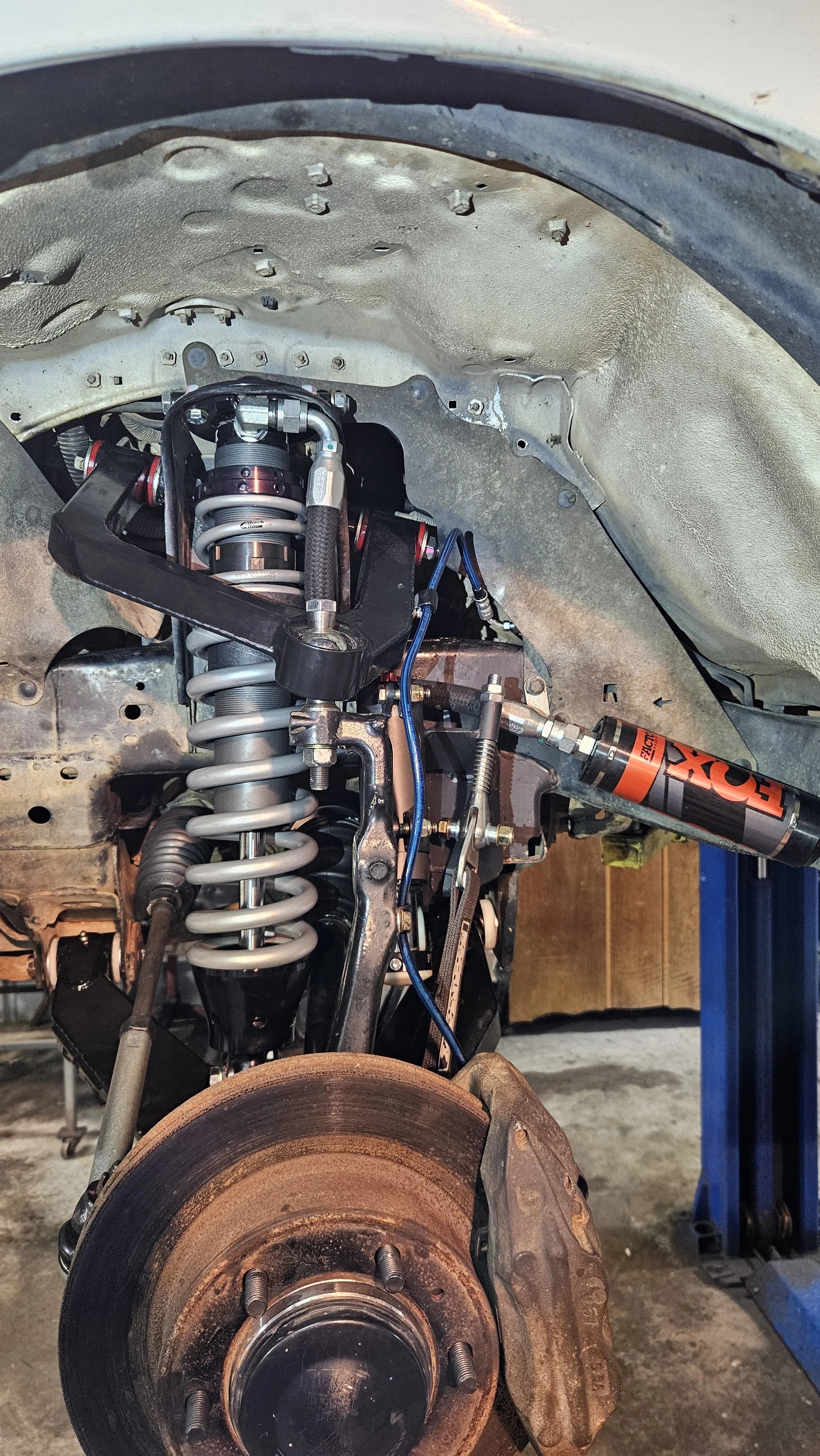 Close-up of a car suspension and brake assembly with an RX-4 shock absorber installed.