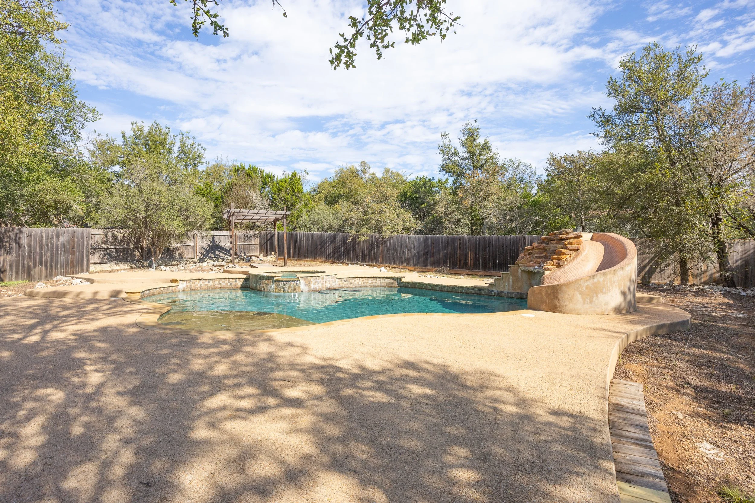 Designed for easy upkeep, the low-maintenance grounds feature a private back deck and an extraordinary backyard retreat—complete with a sparkling in-ground pool, serene waterfall, relaxing spa, and waterslide.