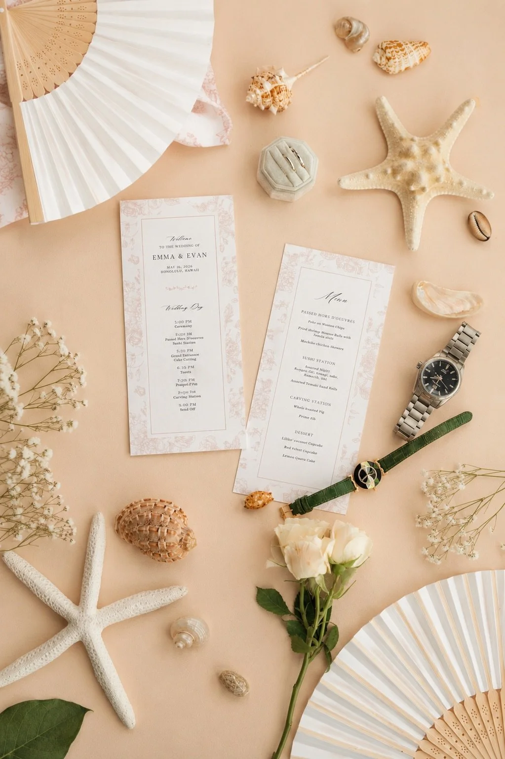 Wedding stationery and day-of cards arranged with flowers, rings, and folding fans.
