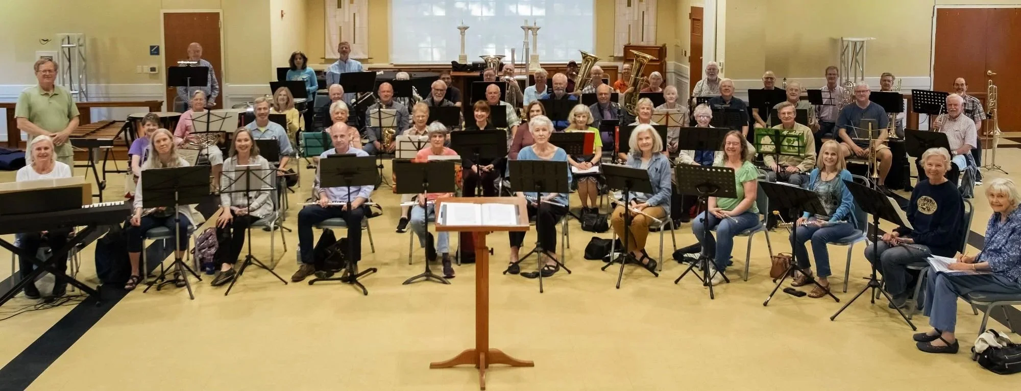 New Horizons Band of Austin Texas rehearsal adults members director seated smiling for camera