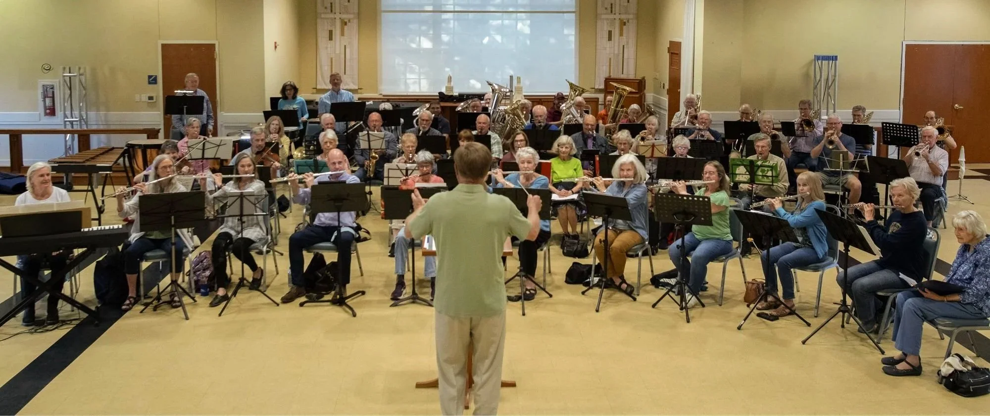 New Horizons Band Austin Texas rehearsal adults playing and conductor conducting with back to camera