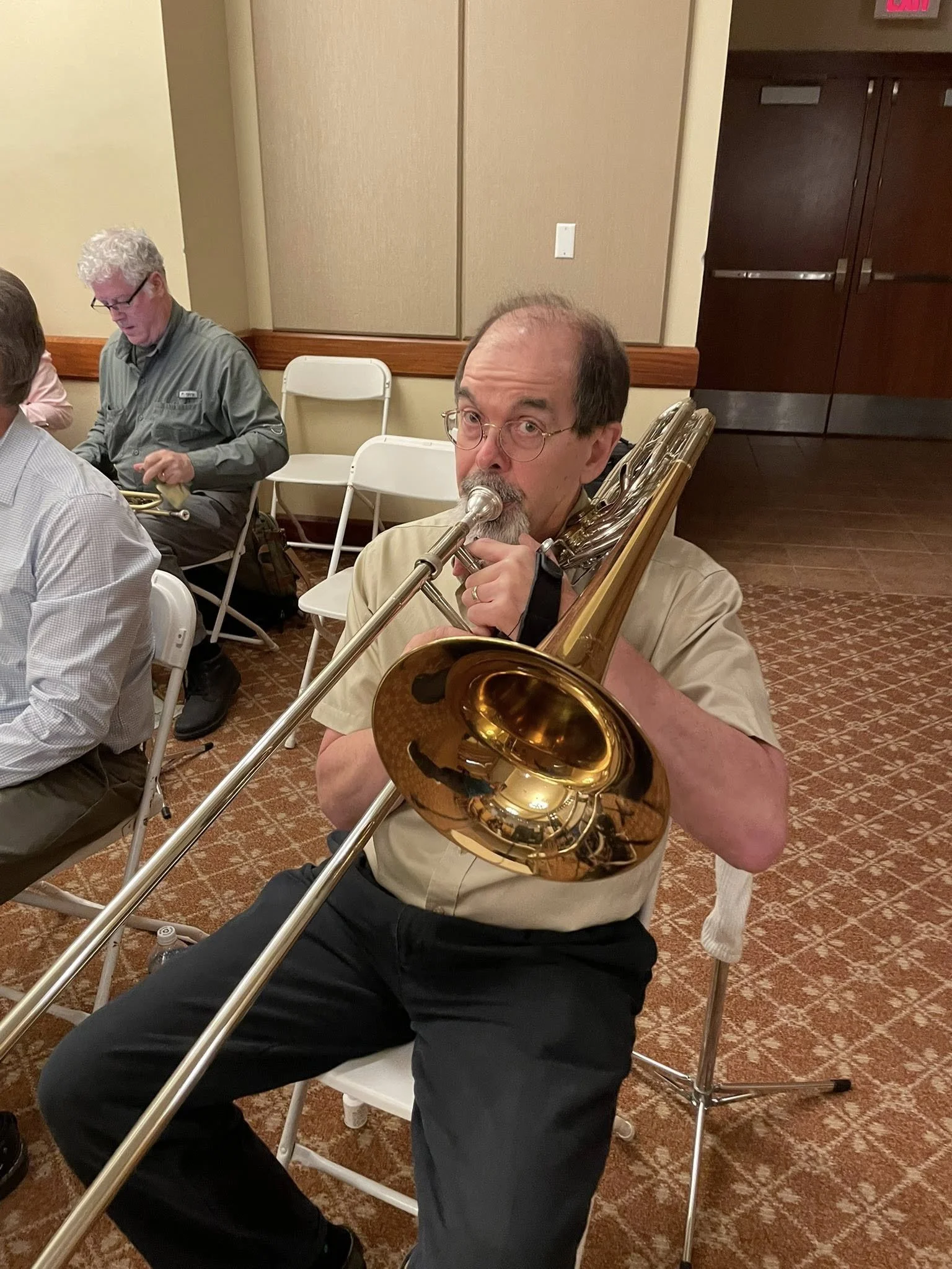Trombonist in the New Horizons Band of Austin, Texas warming up for a concert.