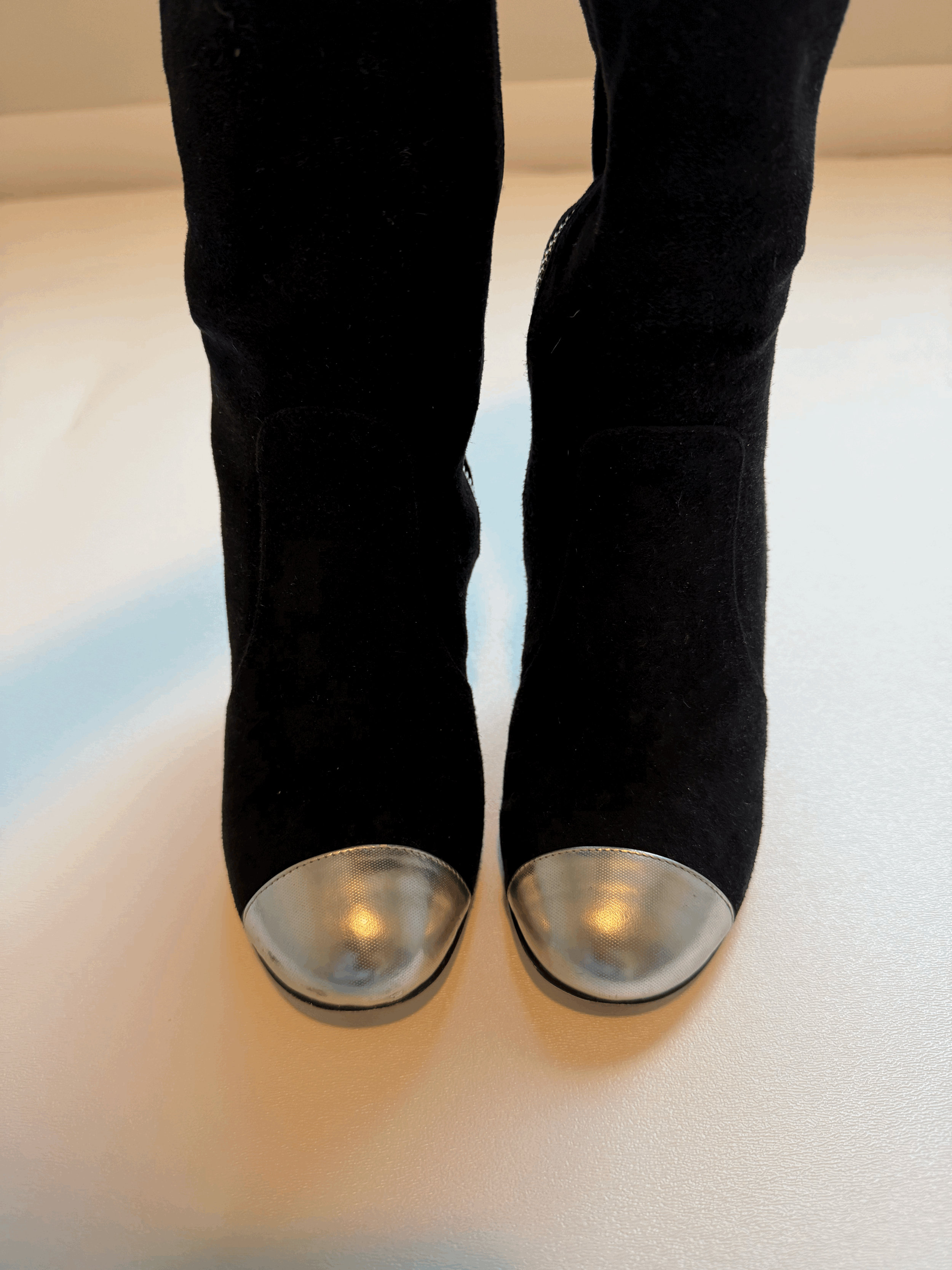 Up close view of toe box on black Chanel wedge boots. shows signs of wear