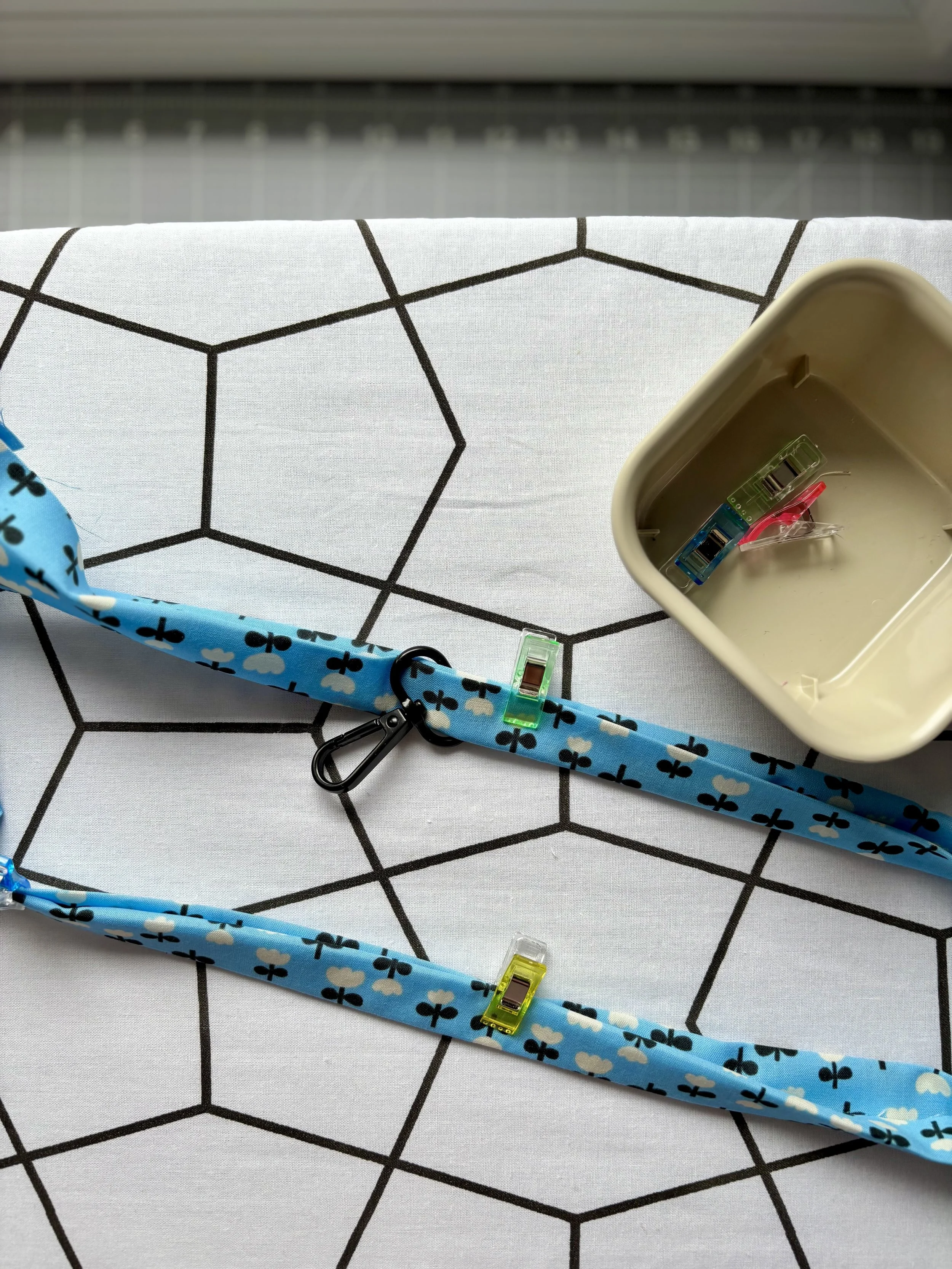 The fabric folded and clipped together with the hardware threaded through before stitching