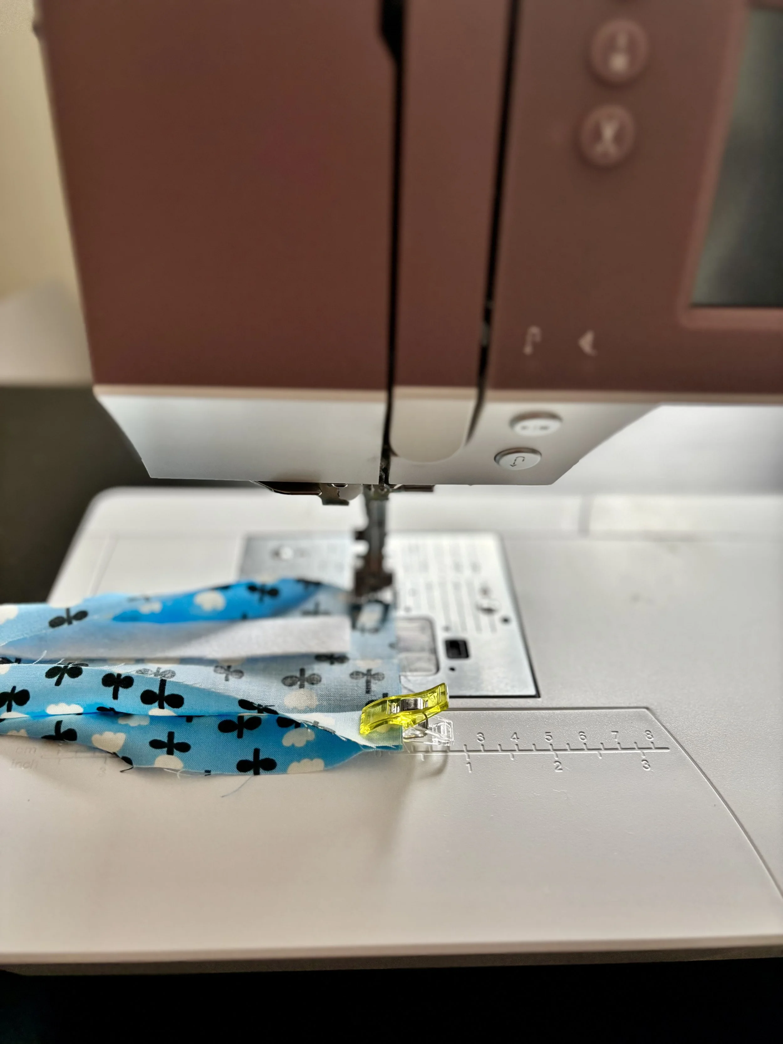 The ends of the fabric that were previously clipped together in front of the sewing machine about to be stitched together