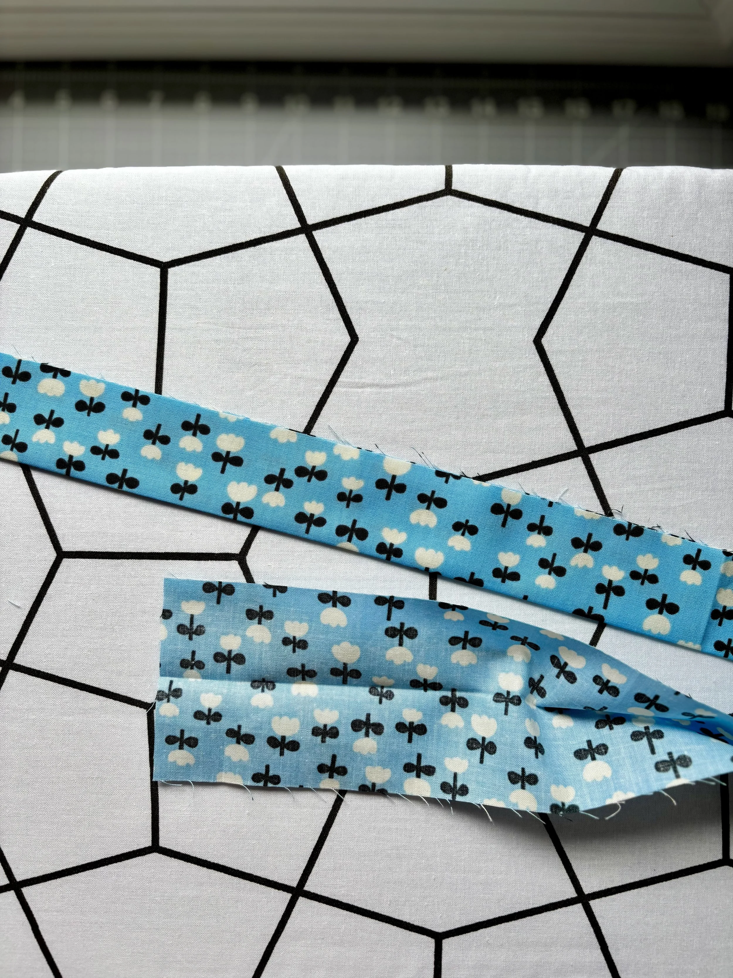 The fabric piece sitting on ironing board showing the pressed center piece