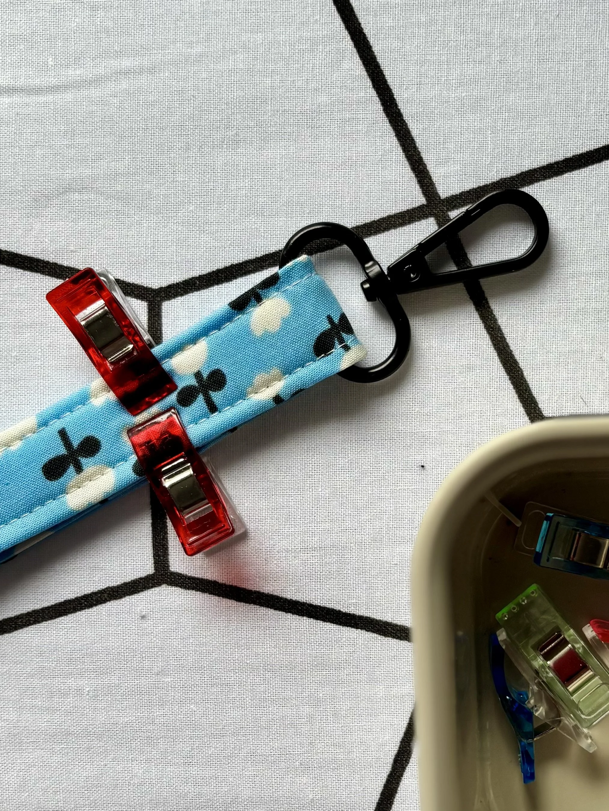 A photo of the fabric lanyard clipped together near the hardware before stitching the hardware in place