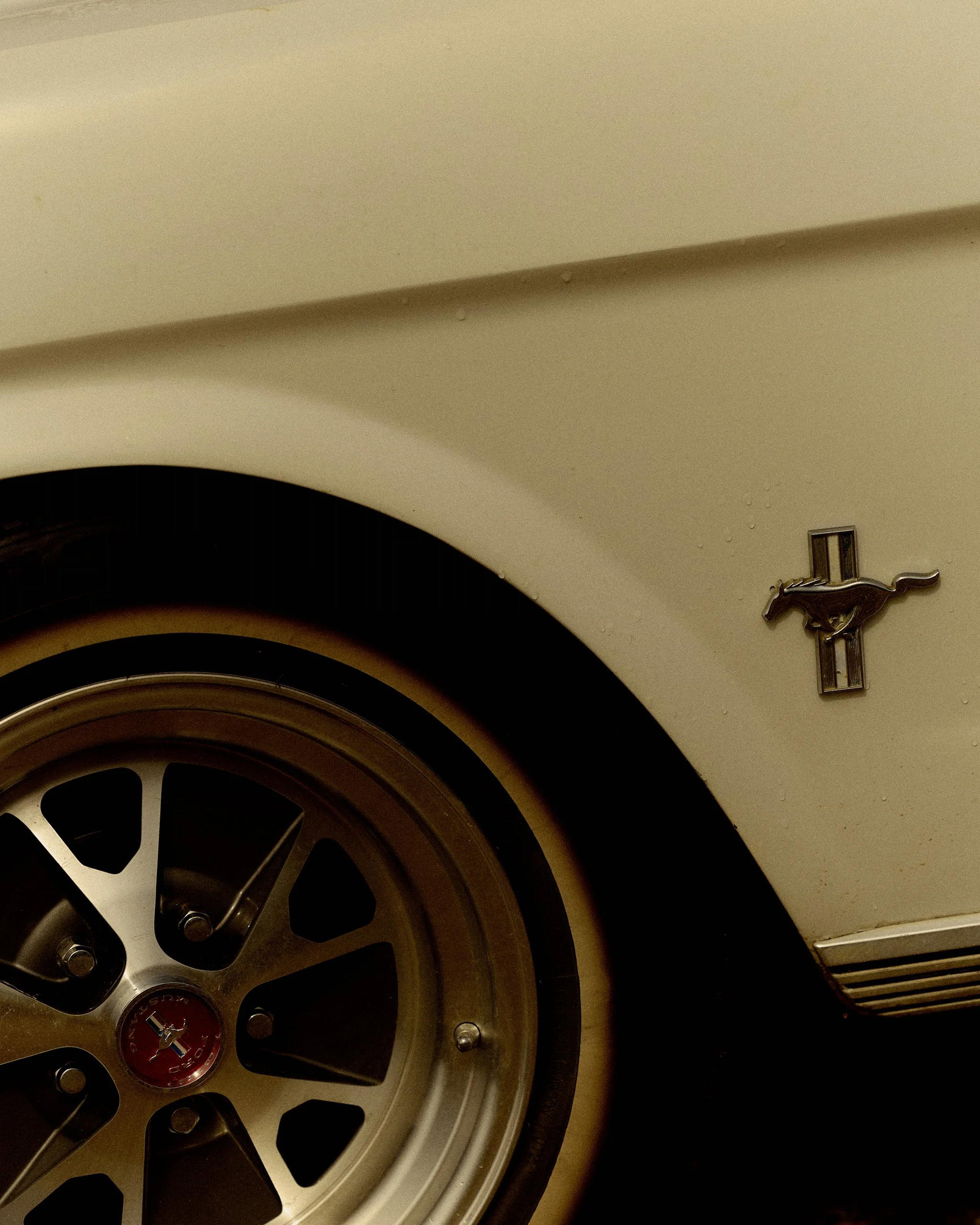 Close-up view of a steering wheel and dashboard of a classic Ford Mustang car.